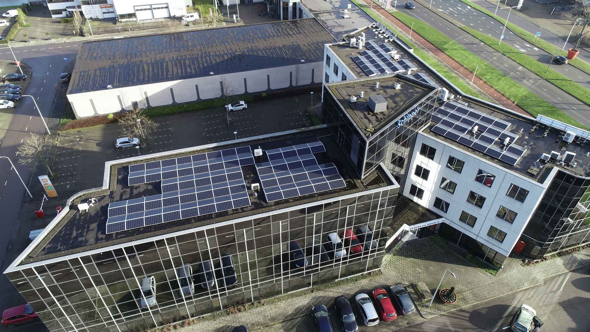 Een luchtfoto van een gebouw met zonnepanelen op het dak