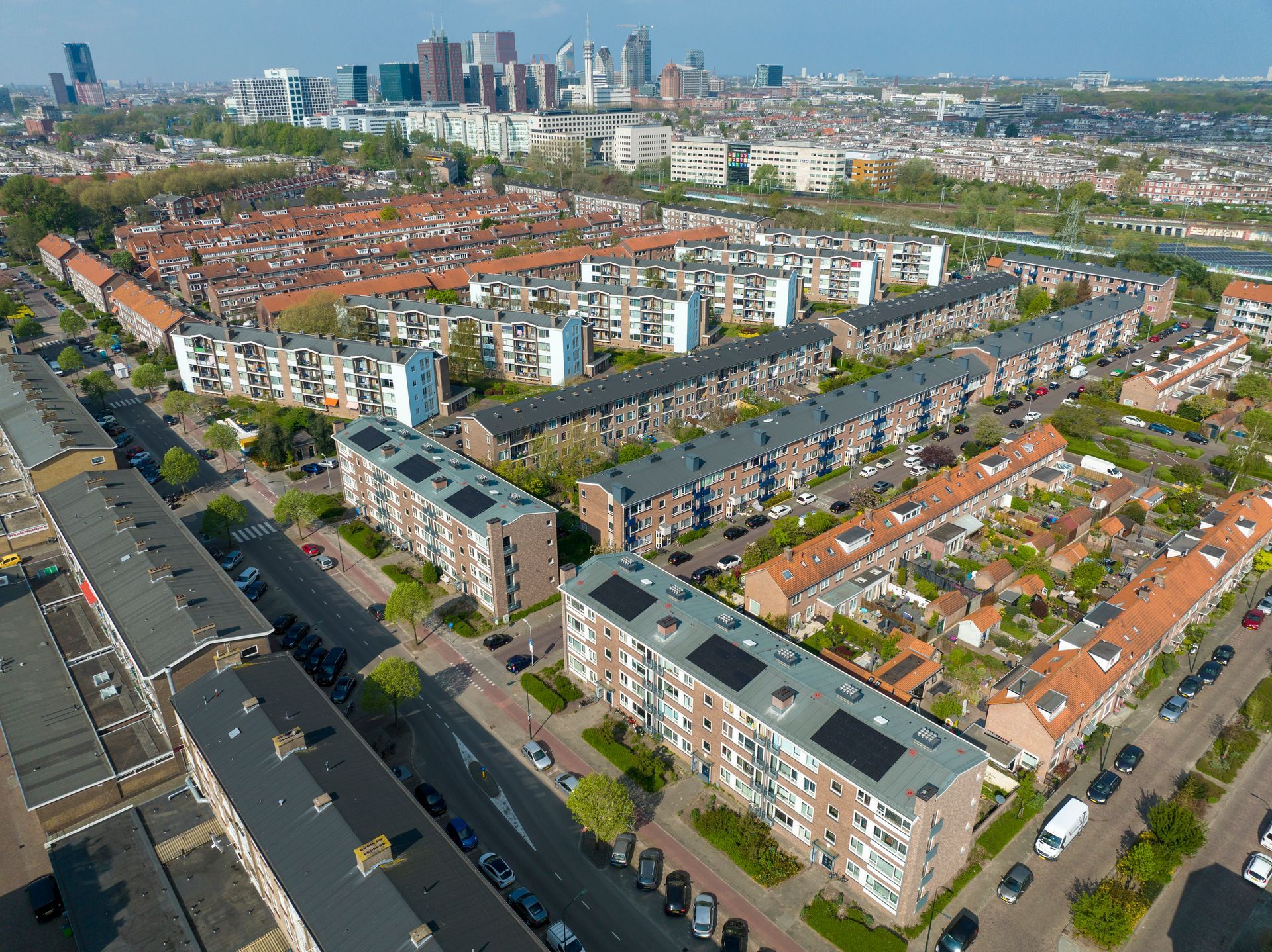 Een luchtfoto van een woonwijk met een stad op de achtergrond.