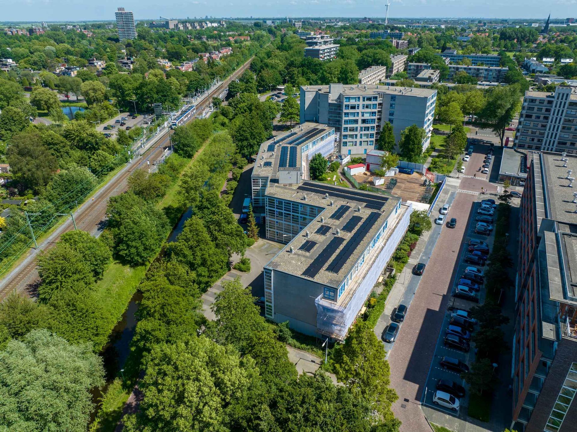 Een luchtfoto van een stad met een gebouw met zonnepanelen op het dak.
