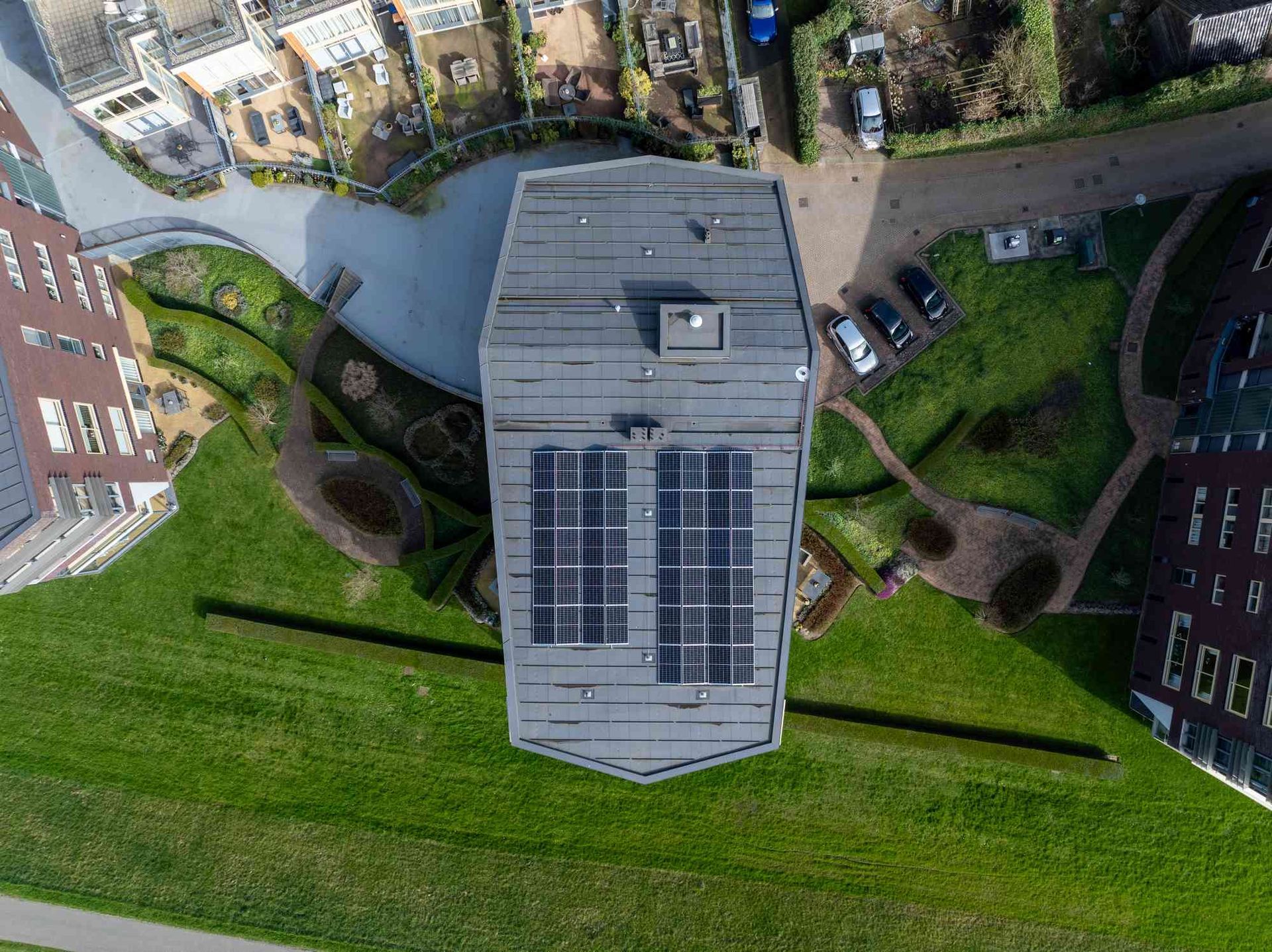Een luchtfoto van een gebouw met zonnepanelen op het dak.