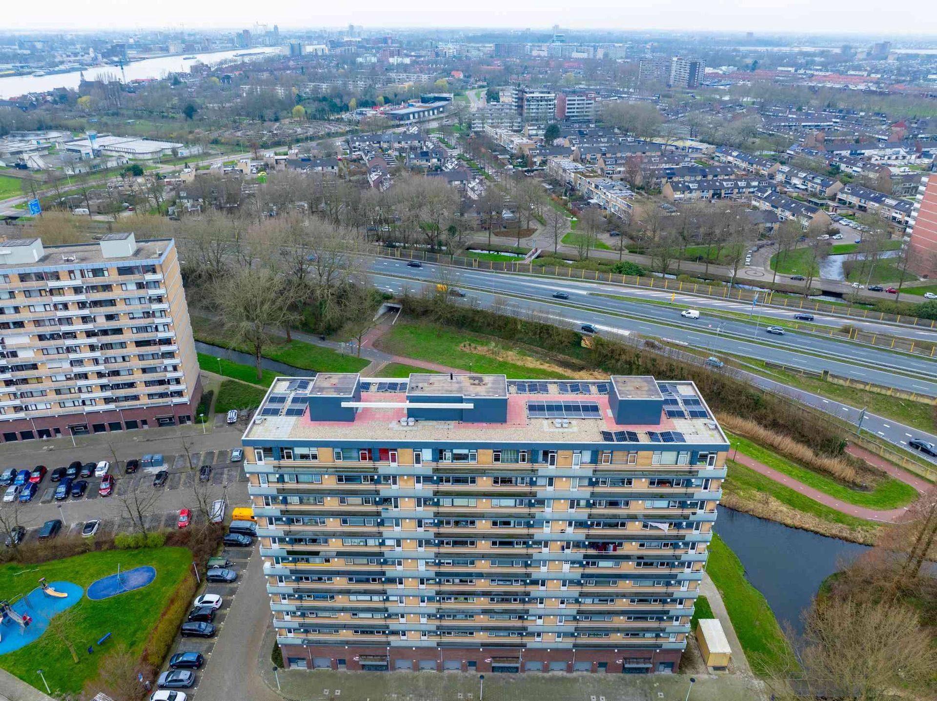 Een luchtfoto van een groot appartementengebouw met zonnepanelen op het dak.