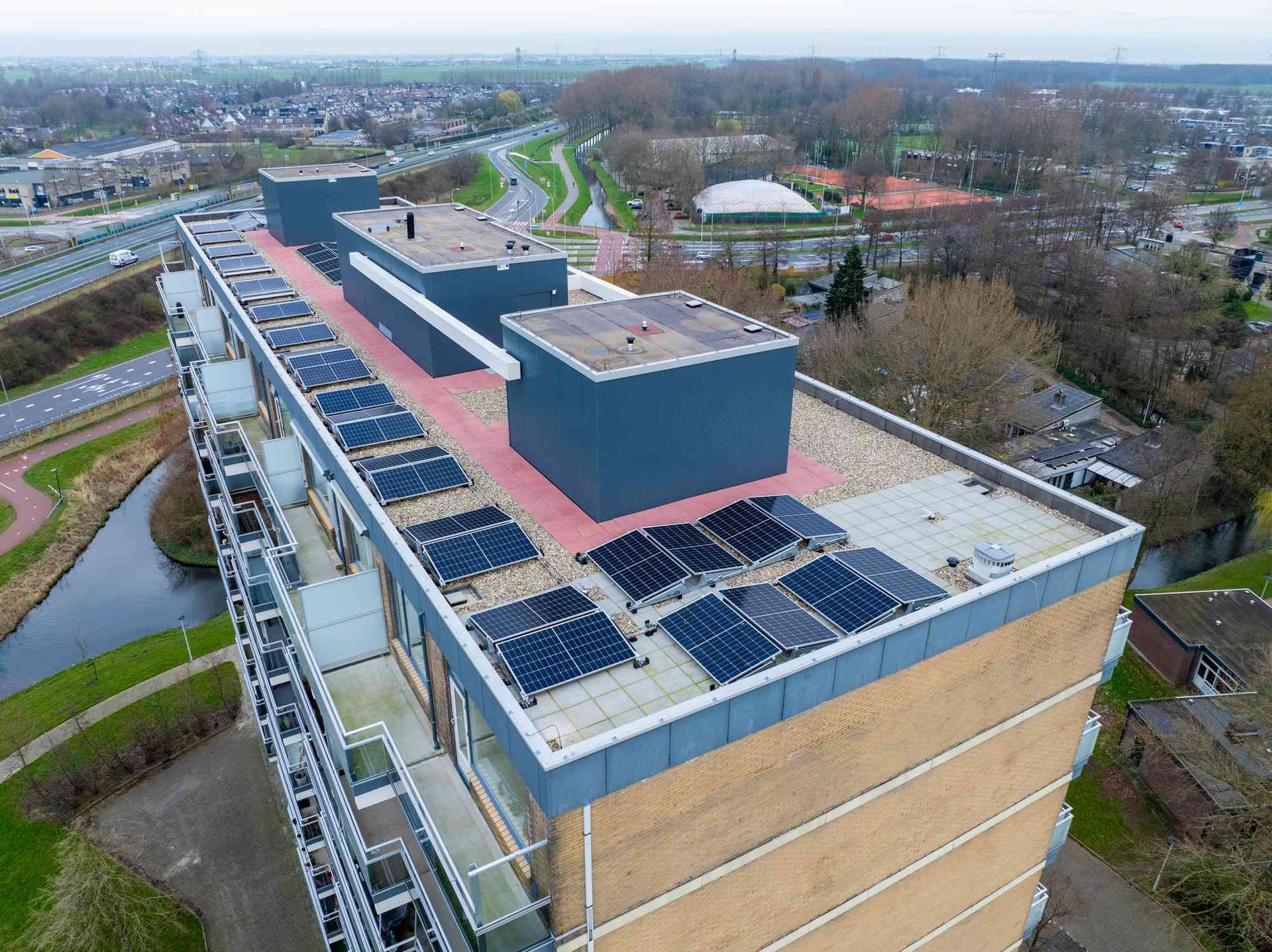 Een luchtfoto van een gebouw met zonnepanelen op het dak.