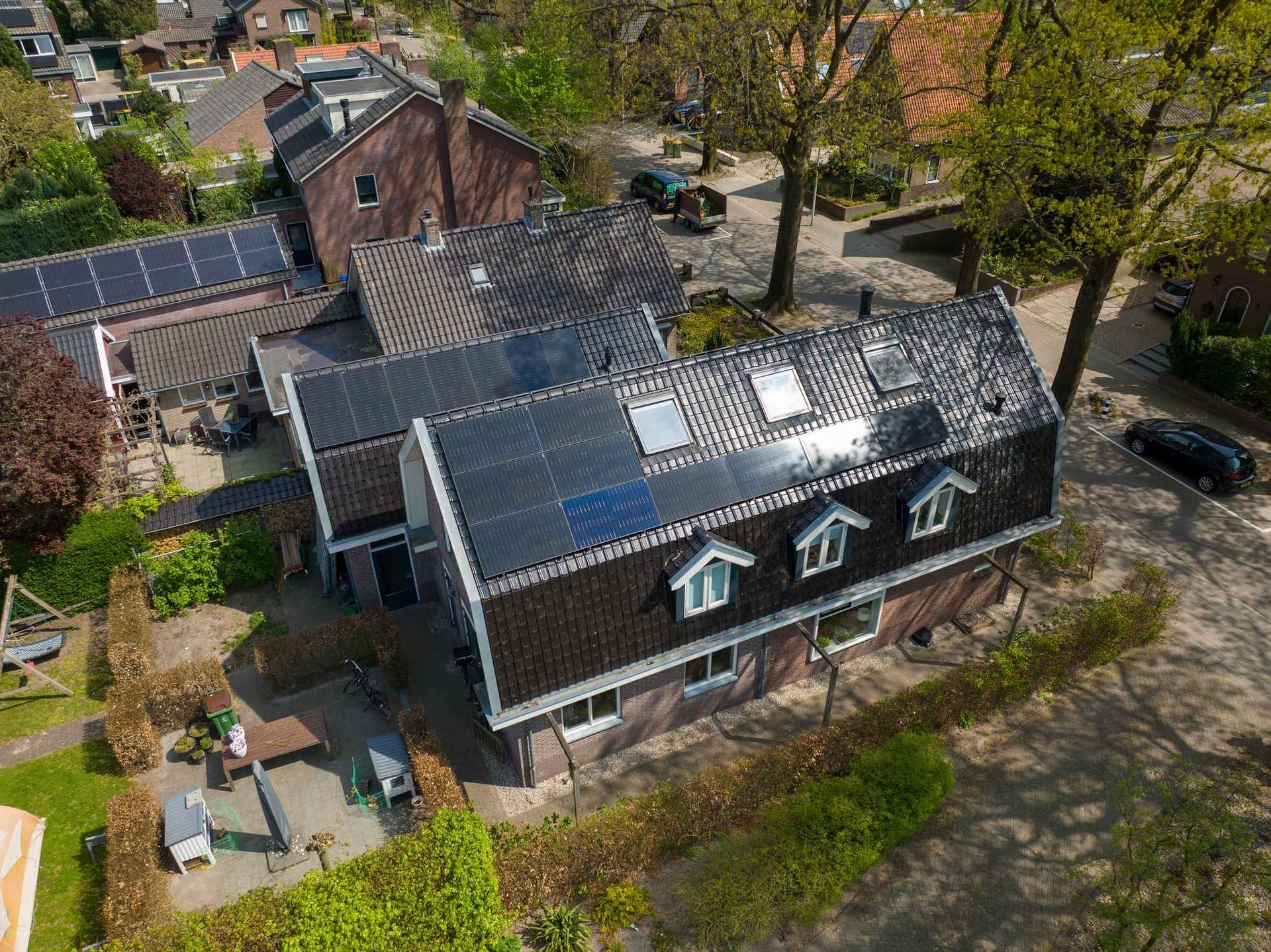 Een luchtfoto van een huis met zonnepanelen op het dak.