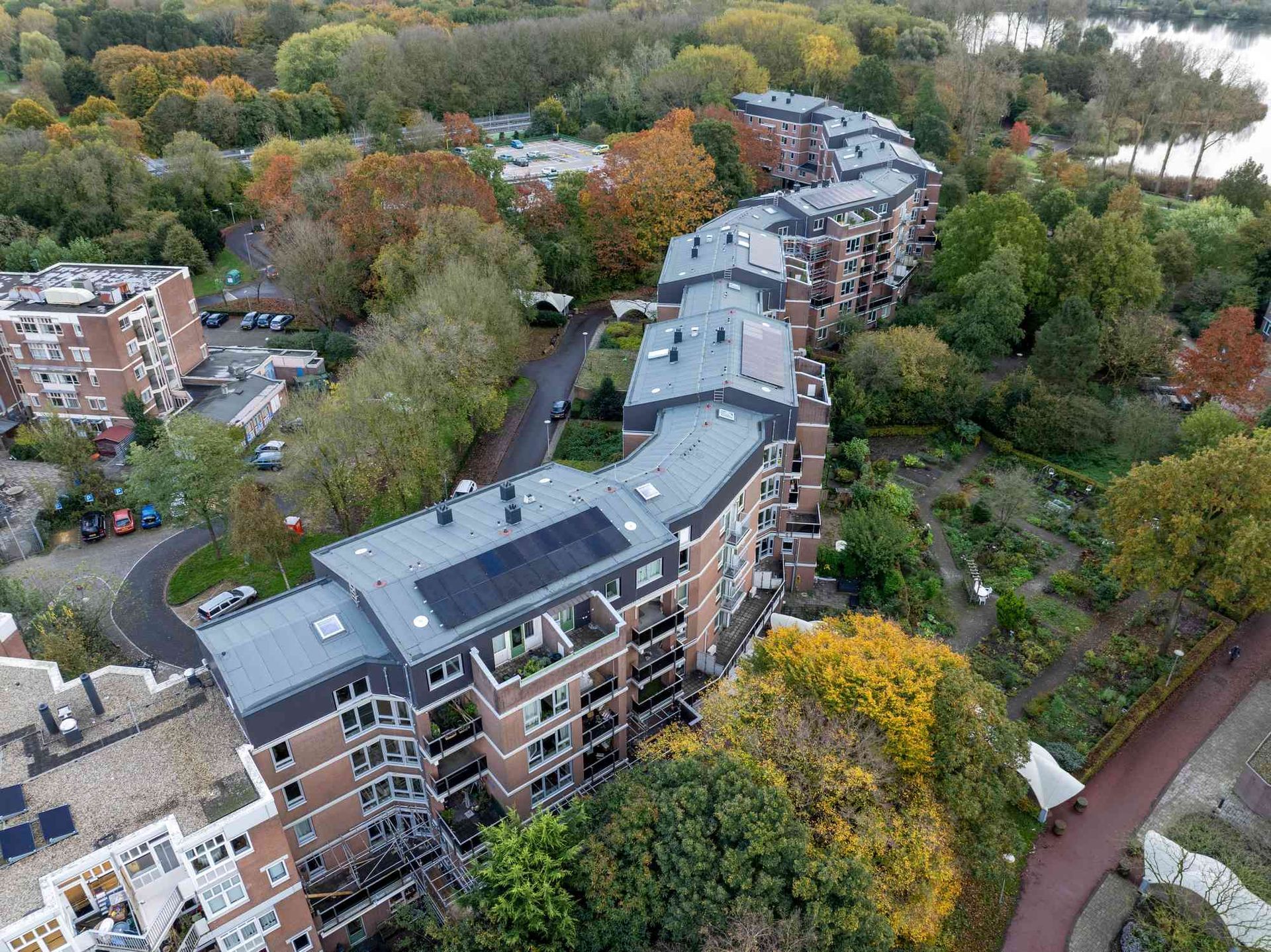 Een luchtfoto van een groot appartementengebouw omgeven door bomen.