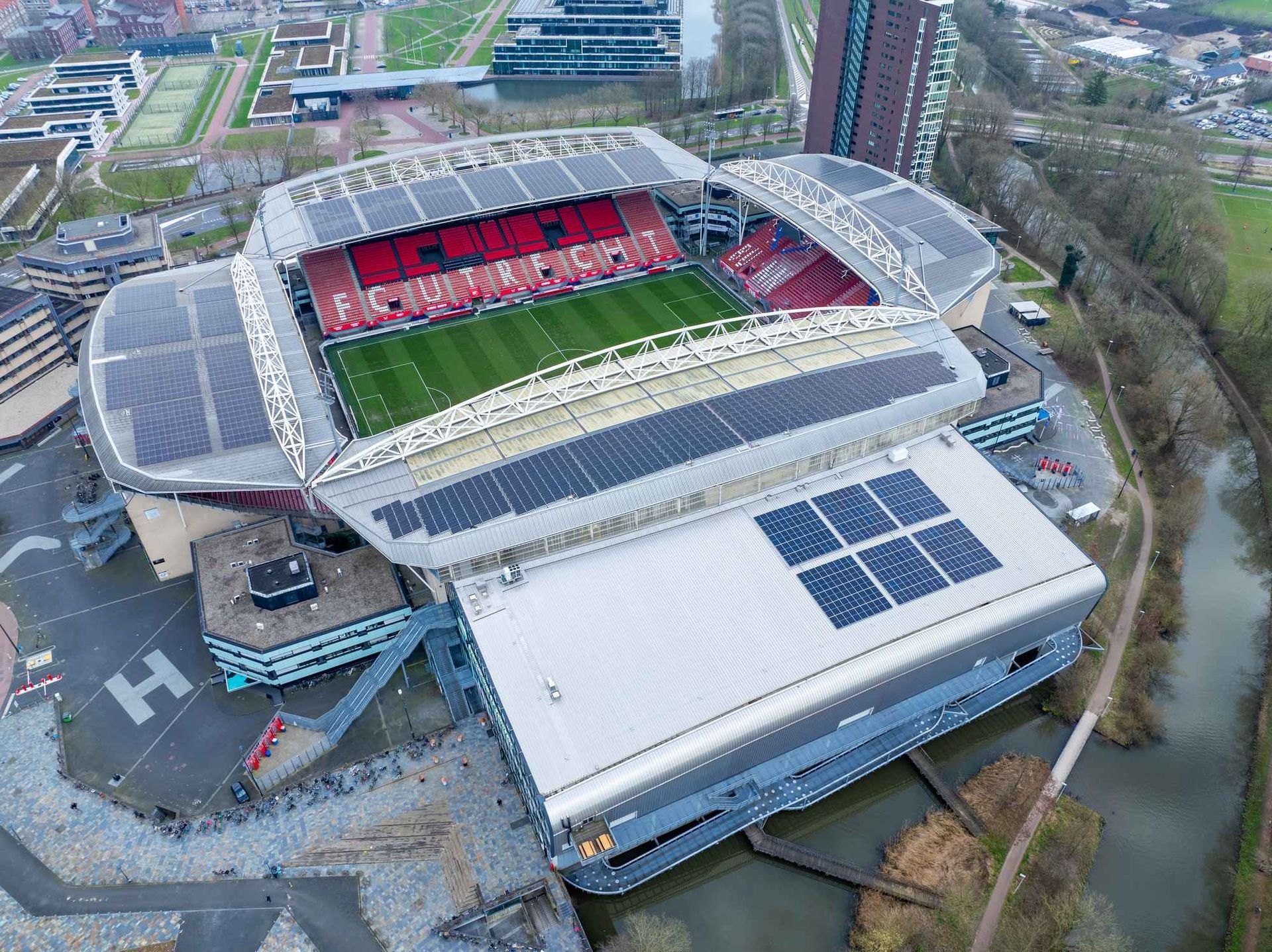 Een luchtfoto van een voetbalstadion met zonnepanelen op het dak.