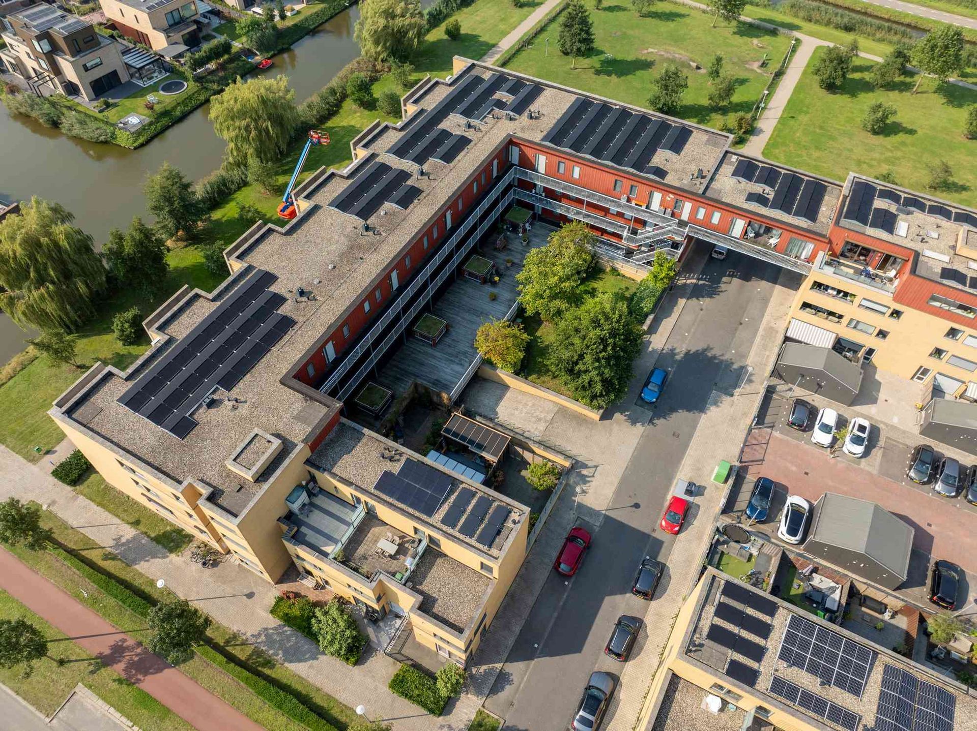 Een luchtfoto van een groot gebouw met zonnepanelen op het dak.