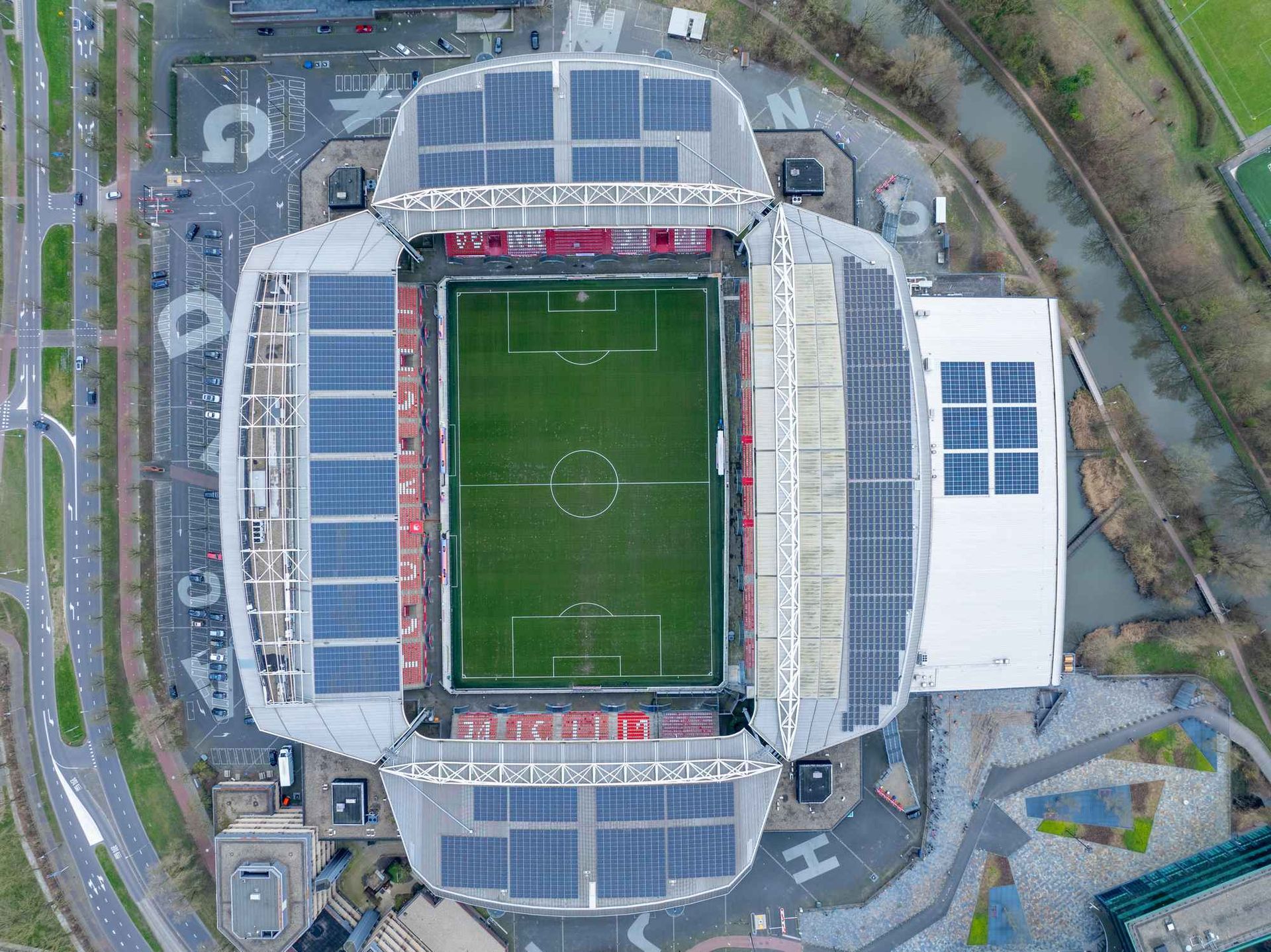 Een luchtfoto van een voetbalstadion met zonnepanelen op het dak.