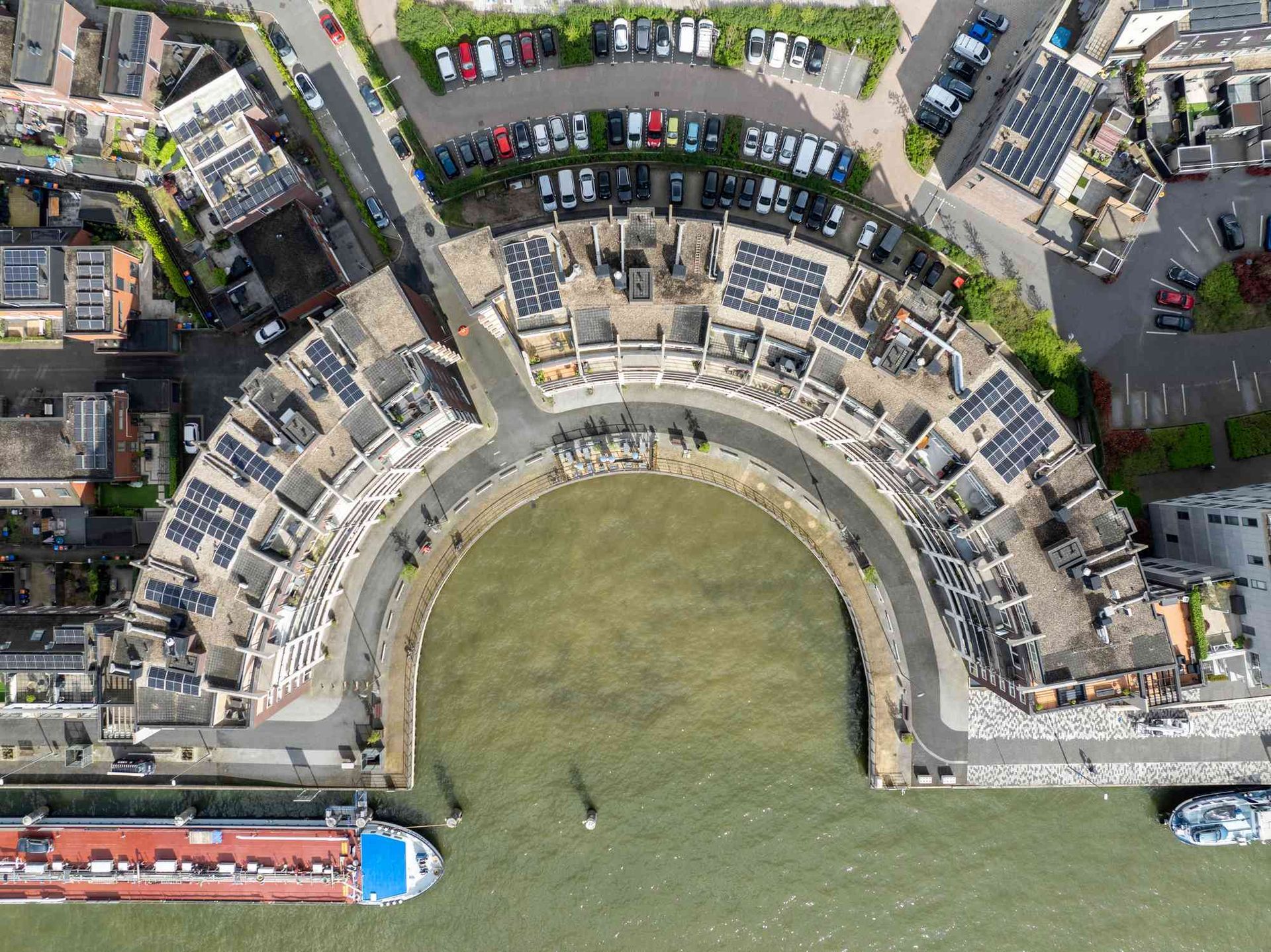 Een luchtfoto van een groot gebouw naast een waterlichaam