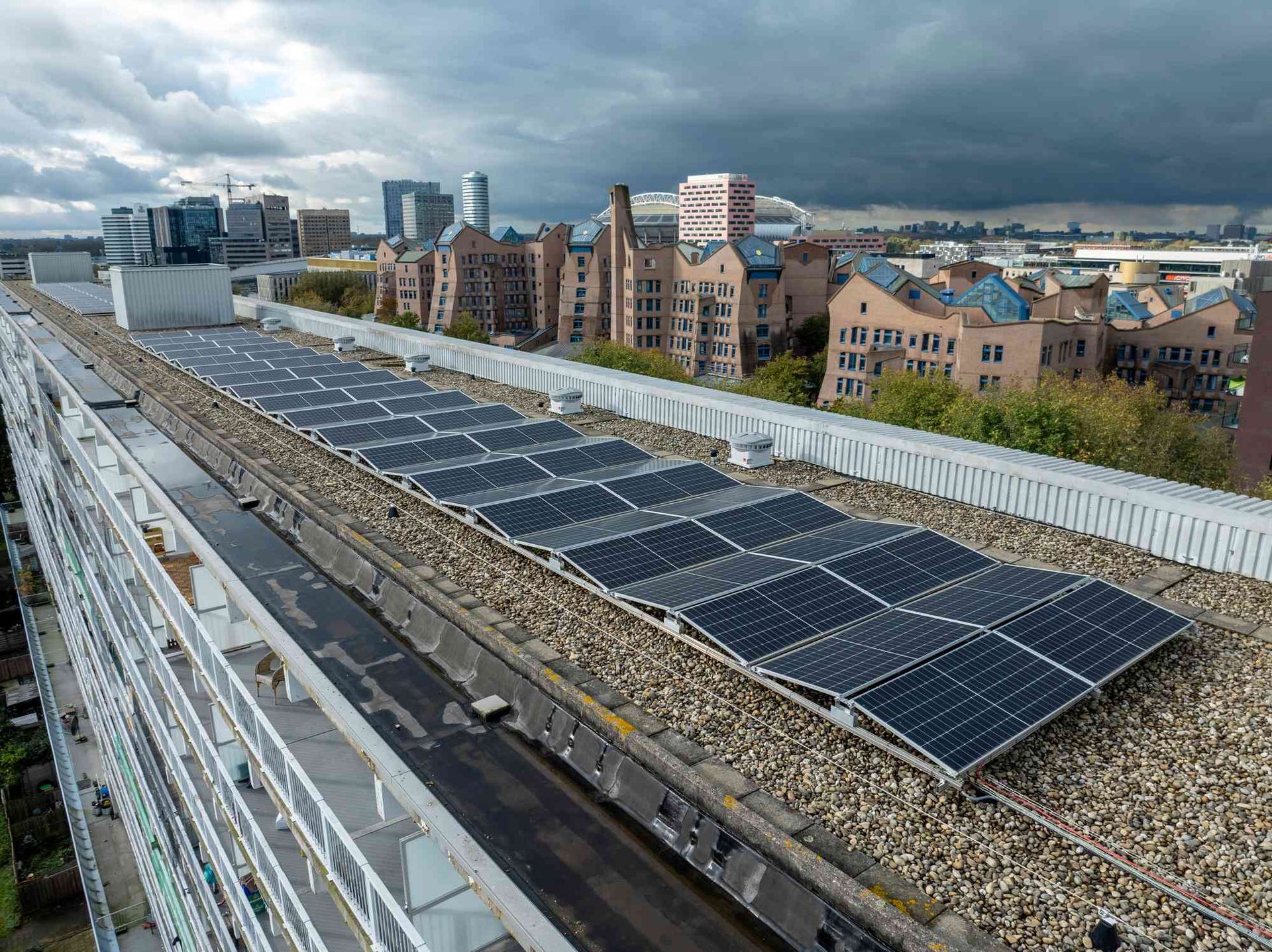 Een rij zonnepanelen op het dak van een gebouw.