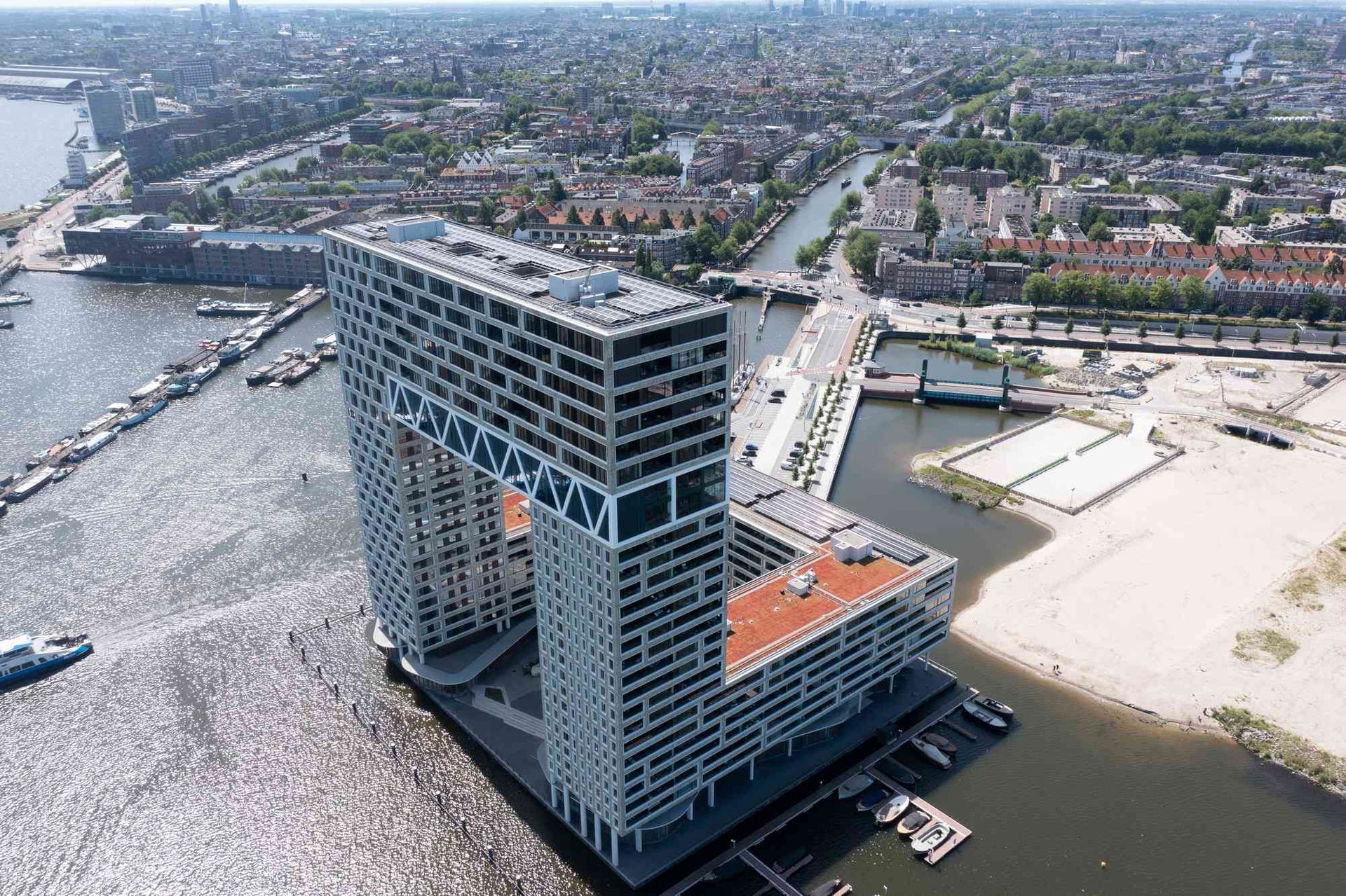 Een luchtfoto van een groot gebouw naast een waterlichaam