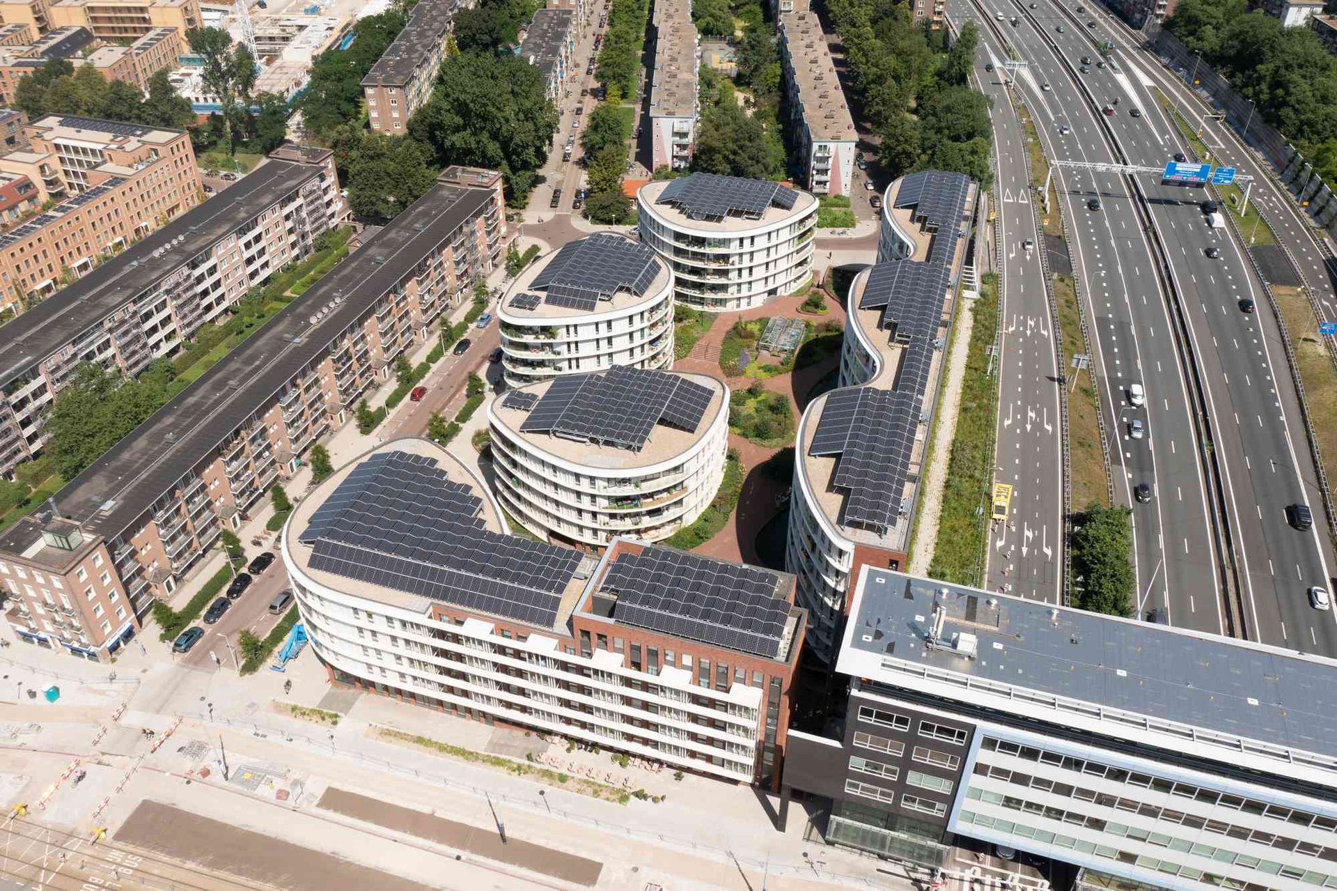 Een luchtfoto van een gebouw met zonnepanelen op het dak.