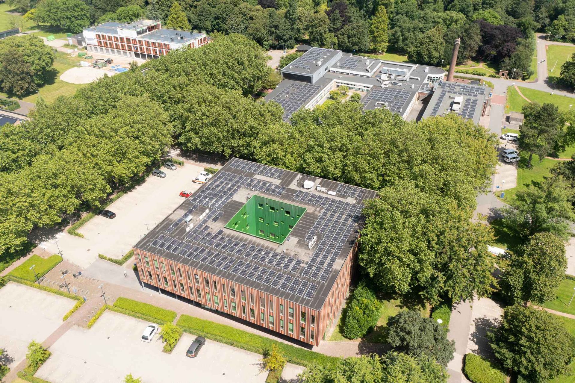 Een luchtfoto van een groot gebouw omgeven door bomen.