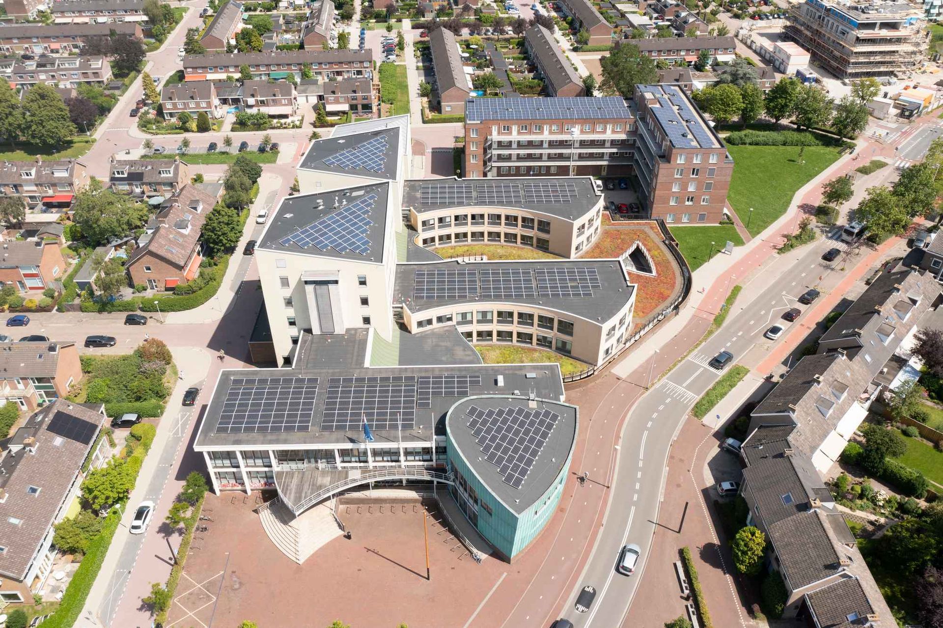 Een luchtfoto van een groot gebouw met zonnepanelen op het dak.