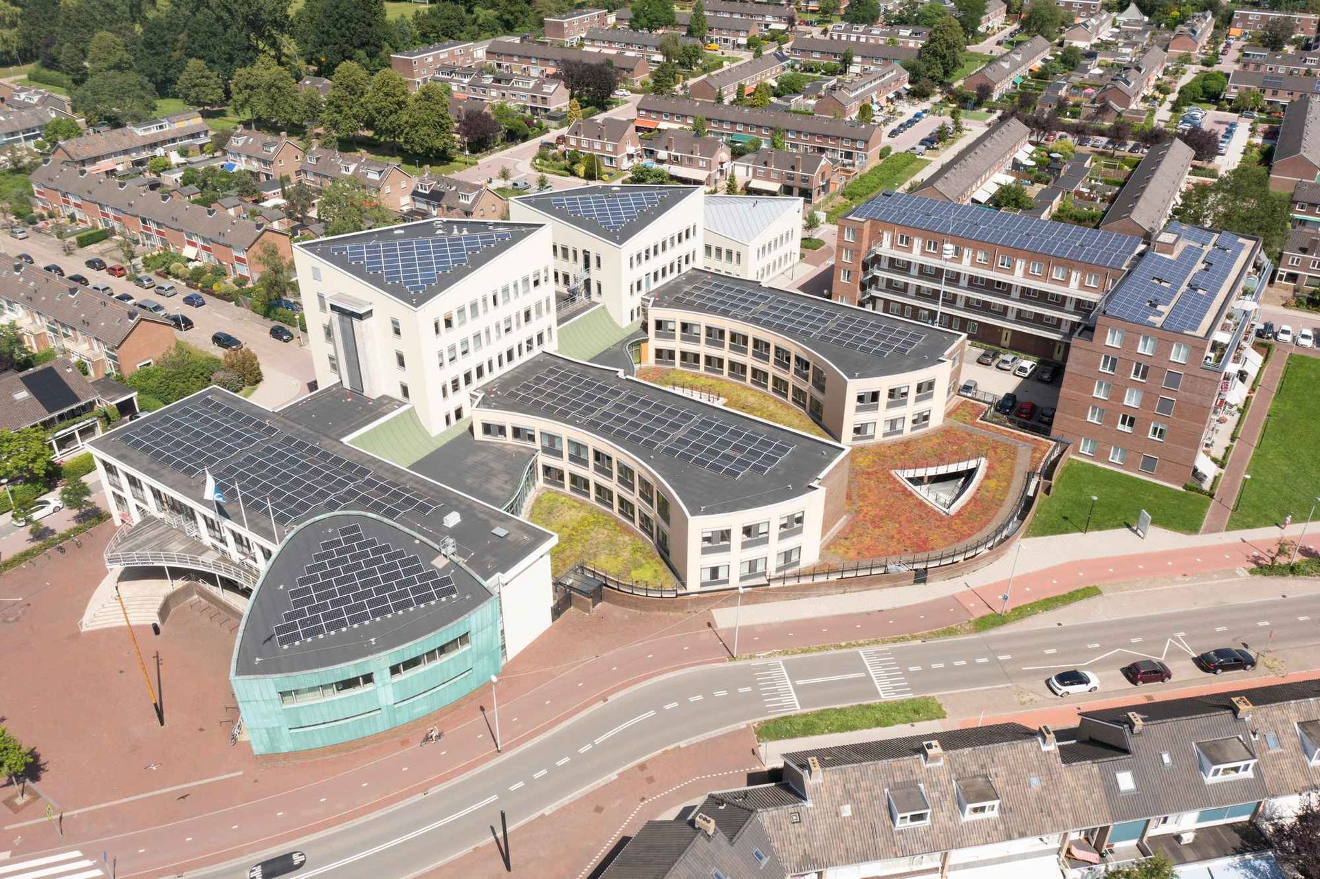 Een luchtfoto van een groot gebouw met zonnepanelen op het dak.
