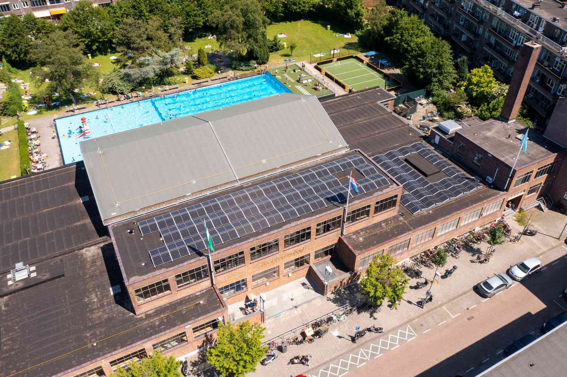 Een luchtfoto van een gebouw met zonnepanelen op het dak.