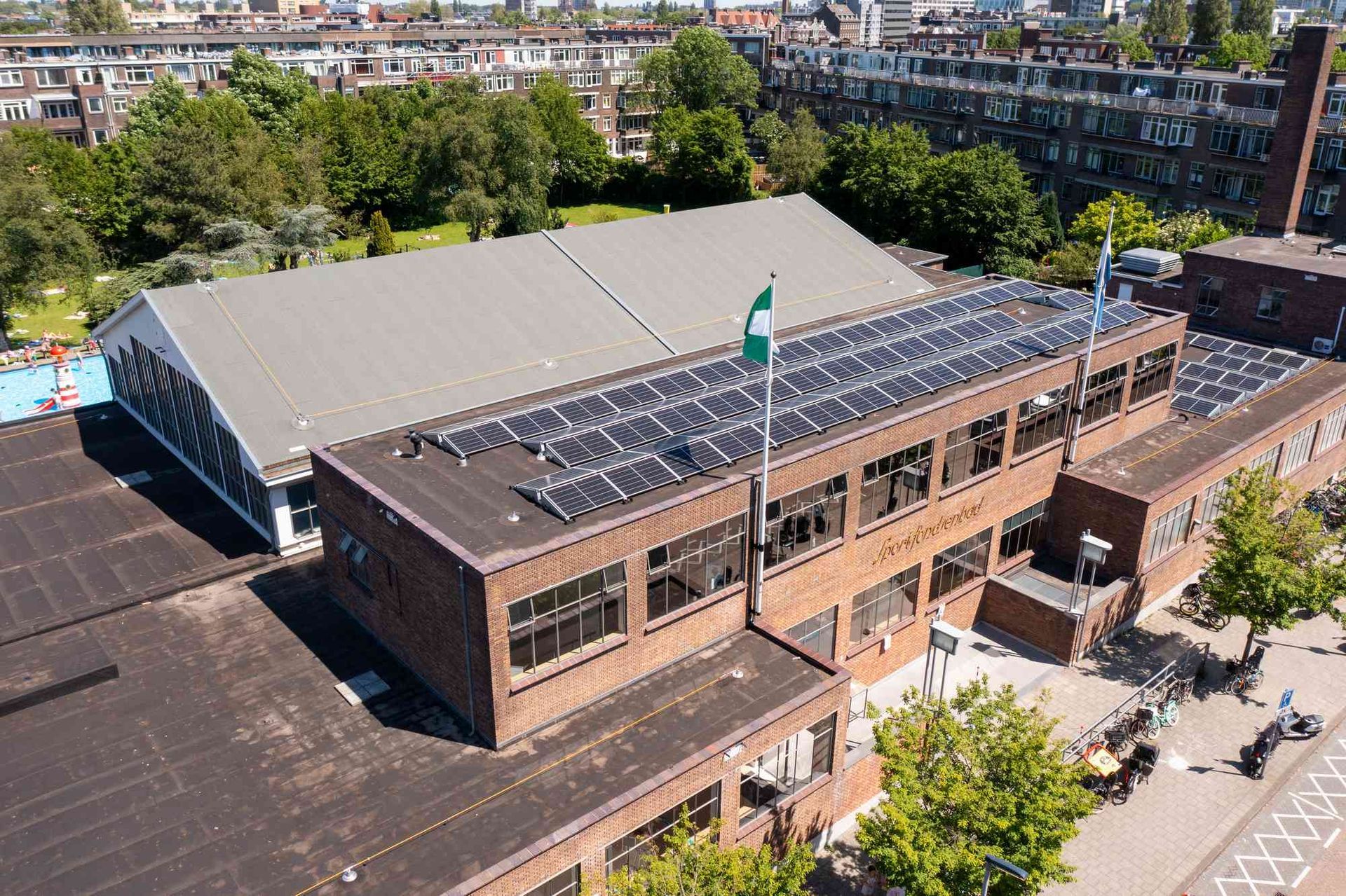 Een luchtfoto van een gebouw met zonnepanelen op het dak.