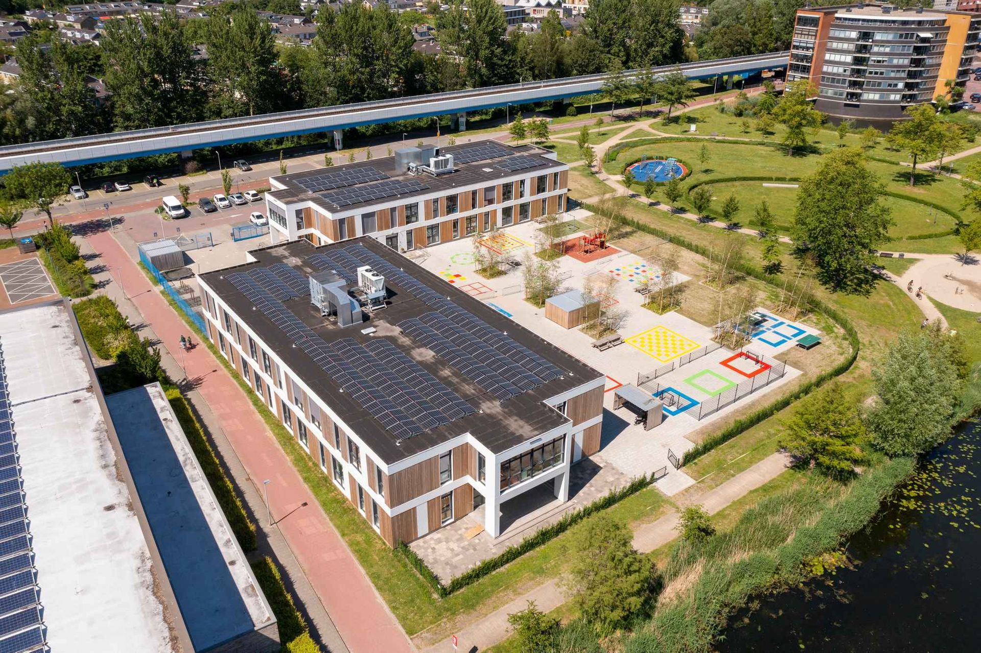 Een luchtfoto van een groot gebouw met zonnepanelen op het dak.