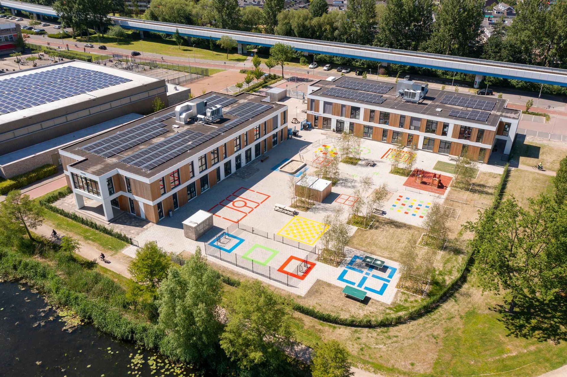 Een luchtfoto van een groot gebouw met zonnepanelen op het dak.
