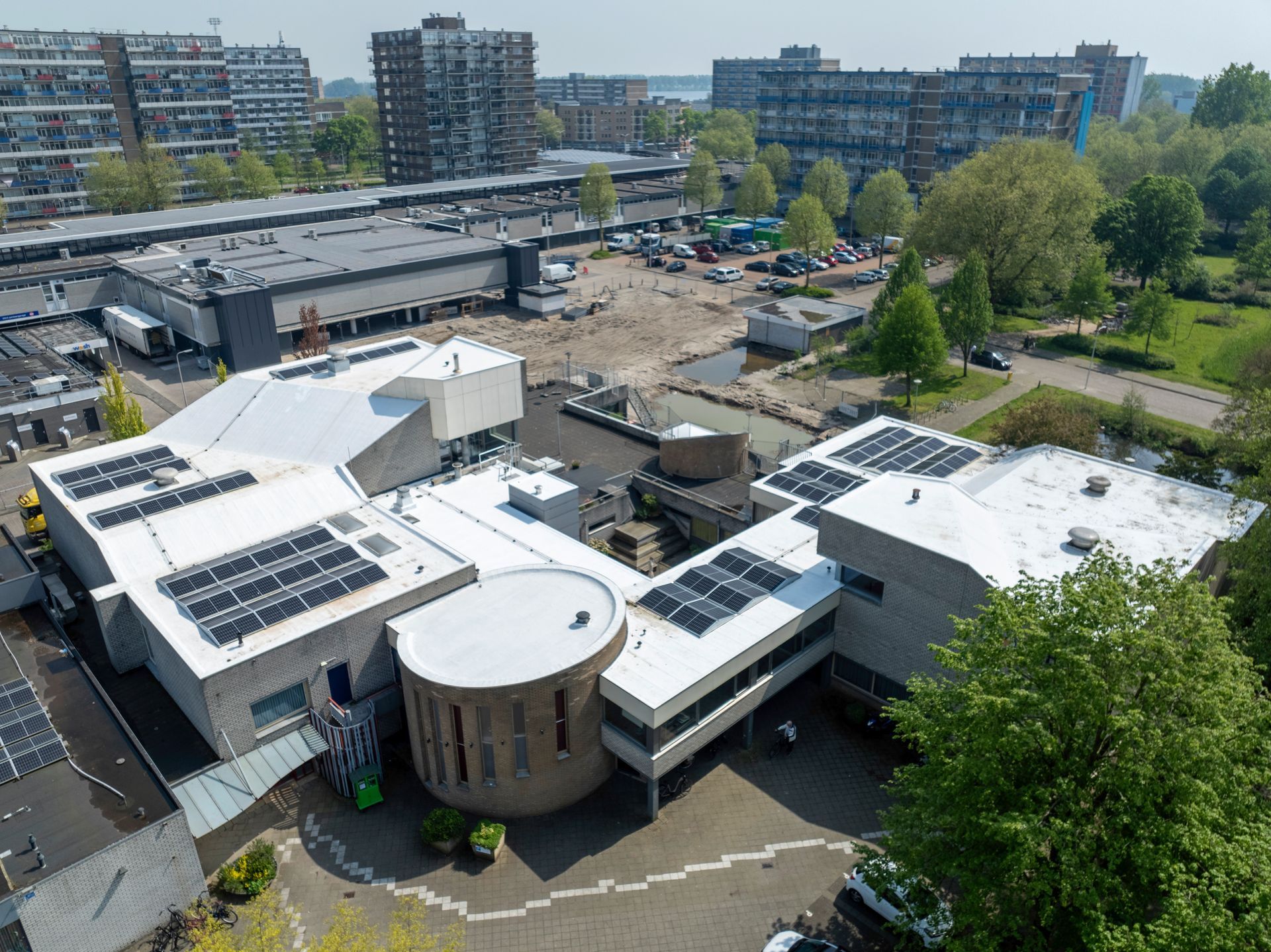 Een luchtfoto van een groot gebouw met zonnepanelen op het dak.
