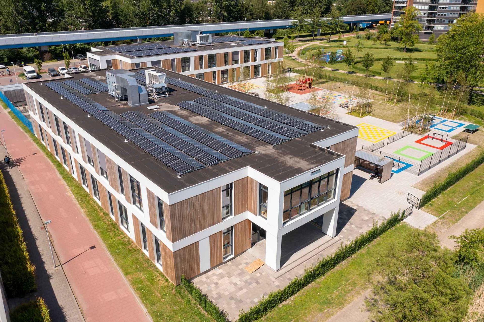 Een luchtfoto van een groot gebouw met zonnepanelen op het dak.
