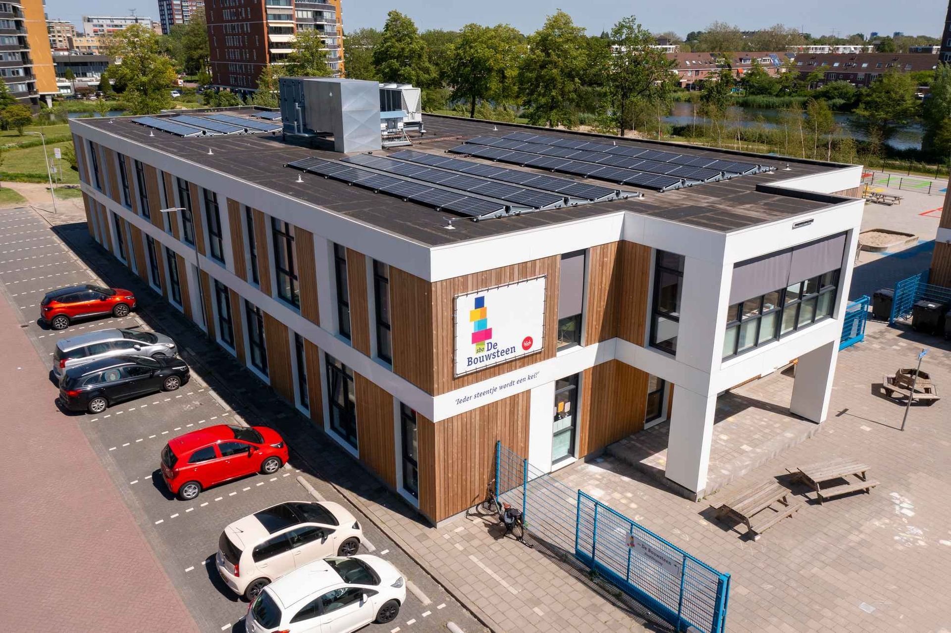 Een luchtfoto van een groot gebouw met zonnepanelen op het dak.