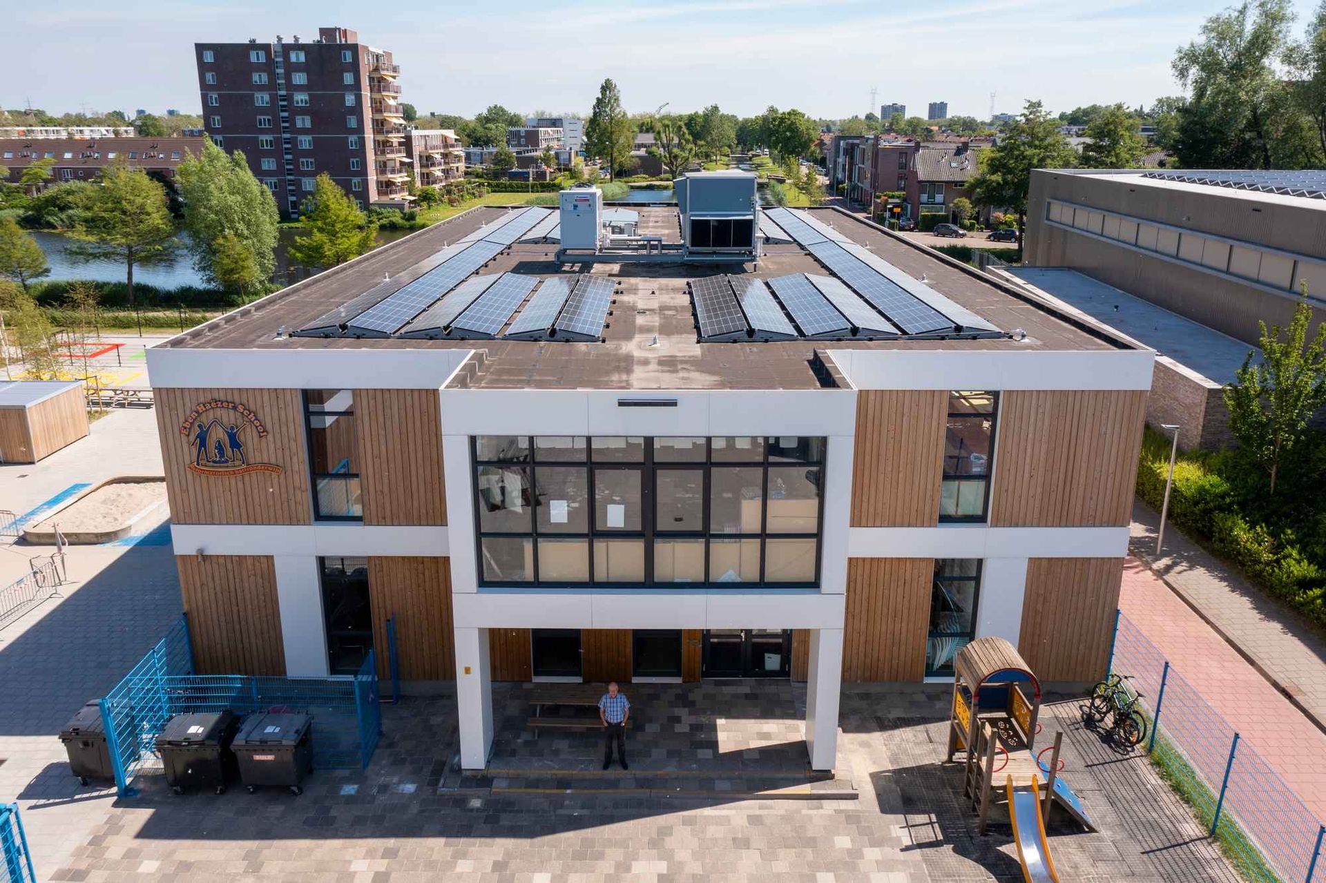 Een luchtfoto van een gebouw met zonnepanelen op het dak.
