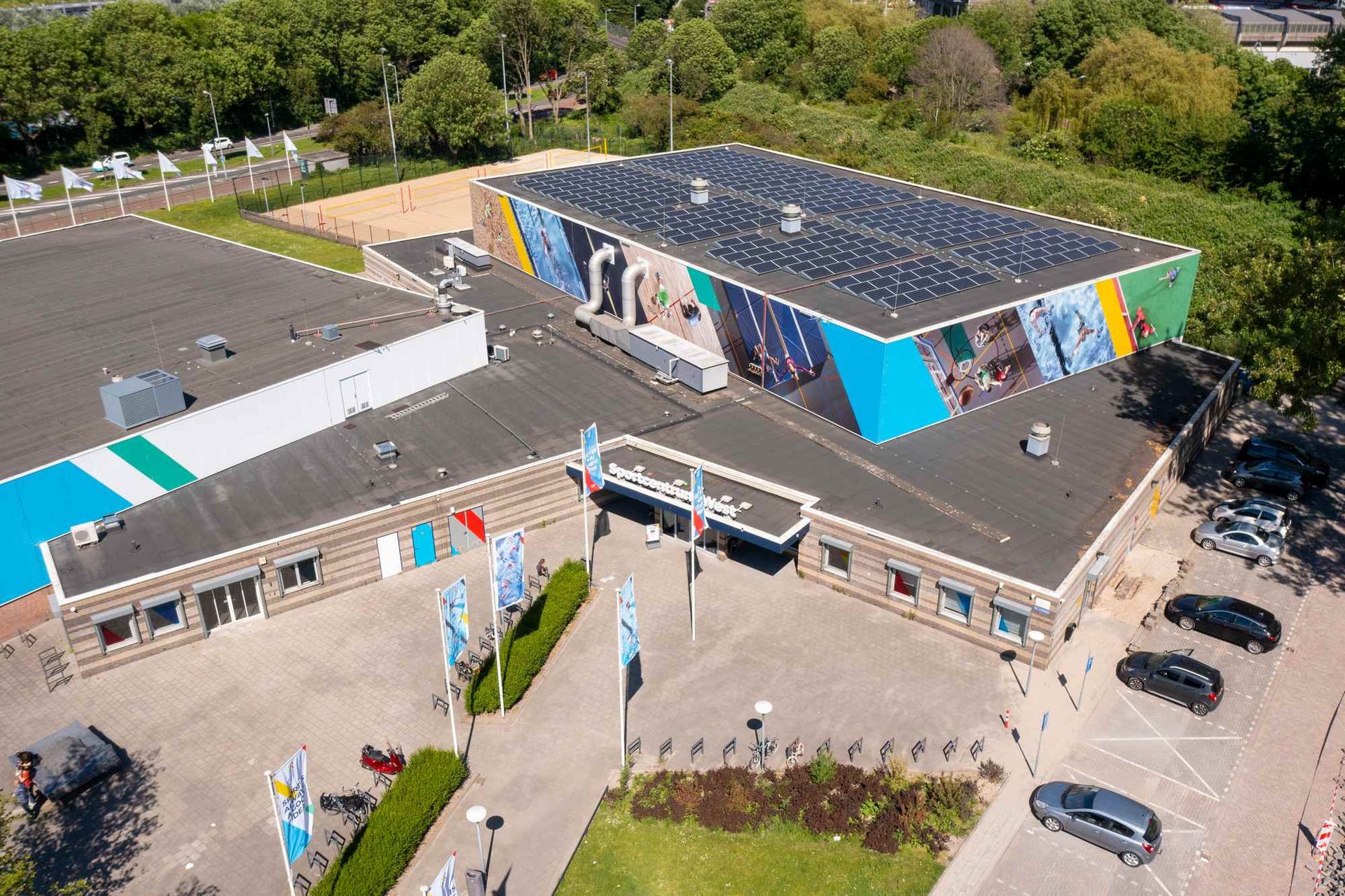 Een luchtfoto van een groot gebouw met zonnepanelen op het dak.