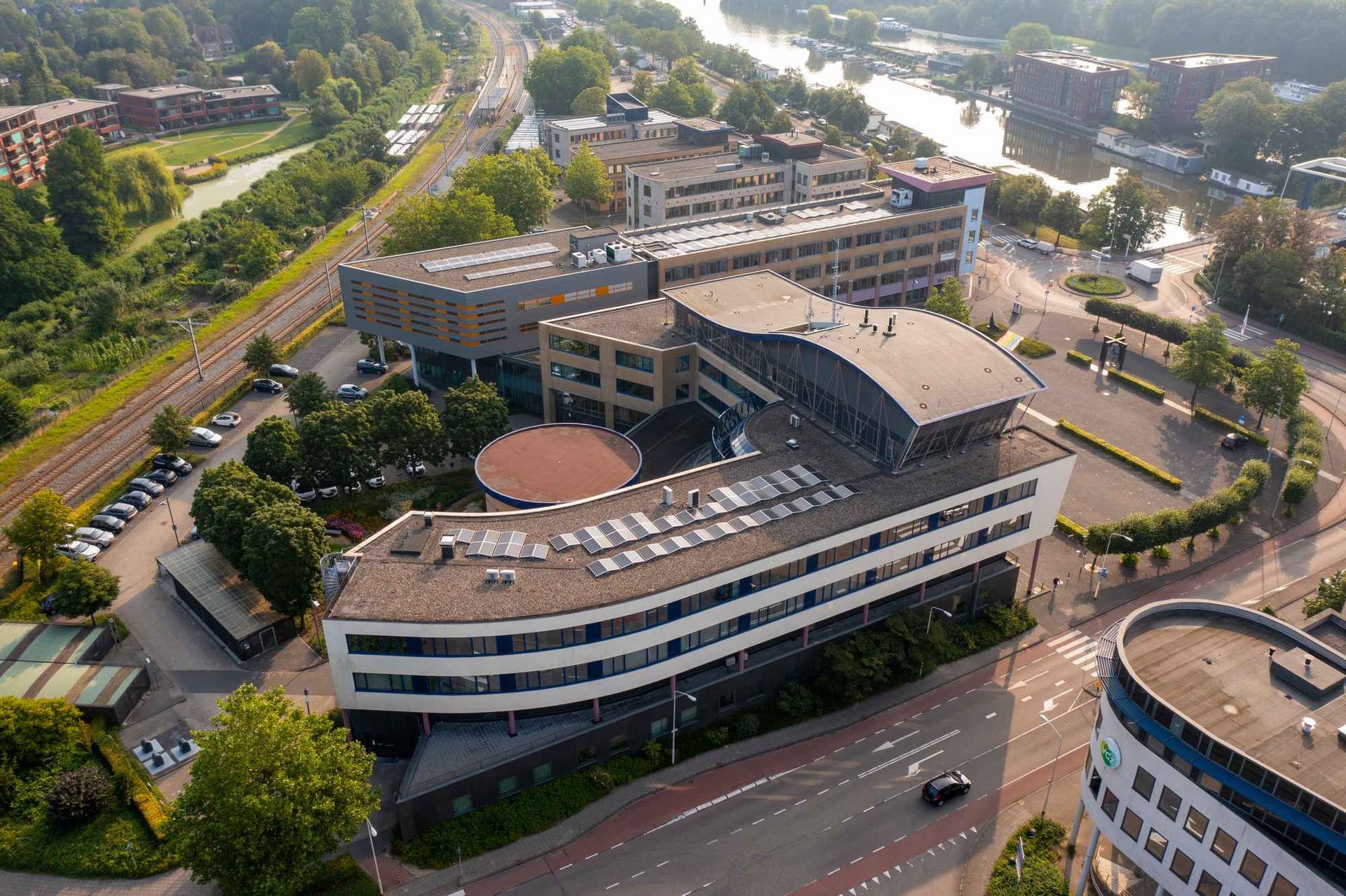 Een luchtfoto van een groot gebouw in een stad met een rivier op de achtergrond.