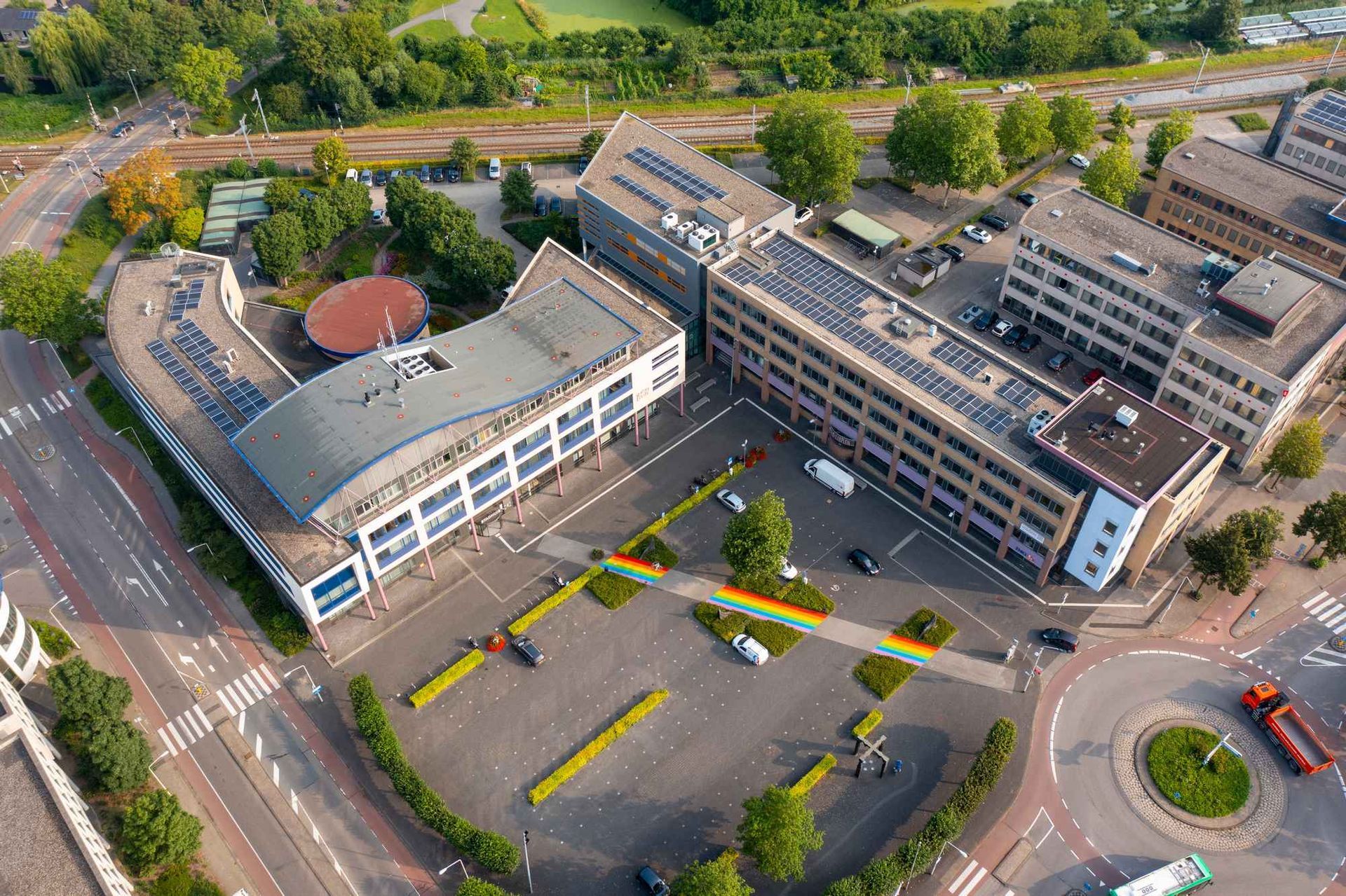 Een luchtfoto van een groot gebouw met zonnepanelen op het dak.