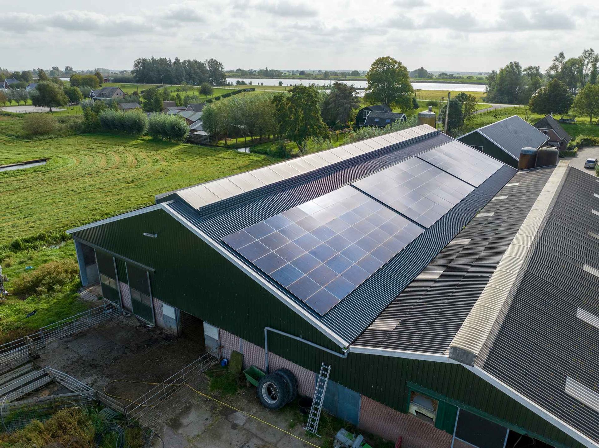 Een luchtfoto van een schuur met zonnepanelen op het dak.