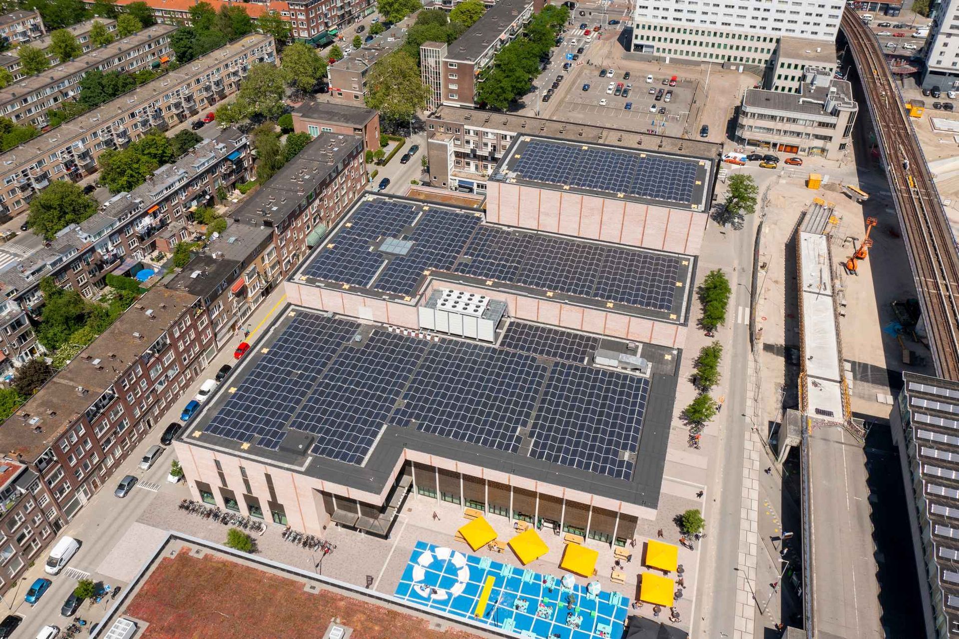 Een luchtfoto van een groot gebouw met zonnepanelen op het dak.