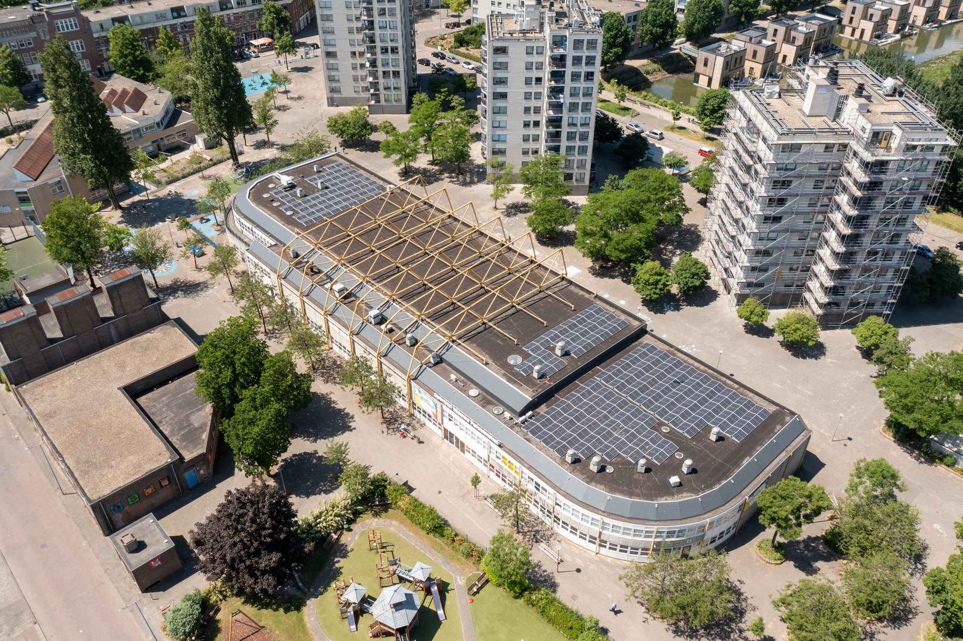 Een luchtfoto van een groot gebouw met zonnepanelen op het dak.