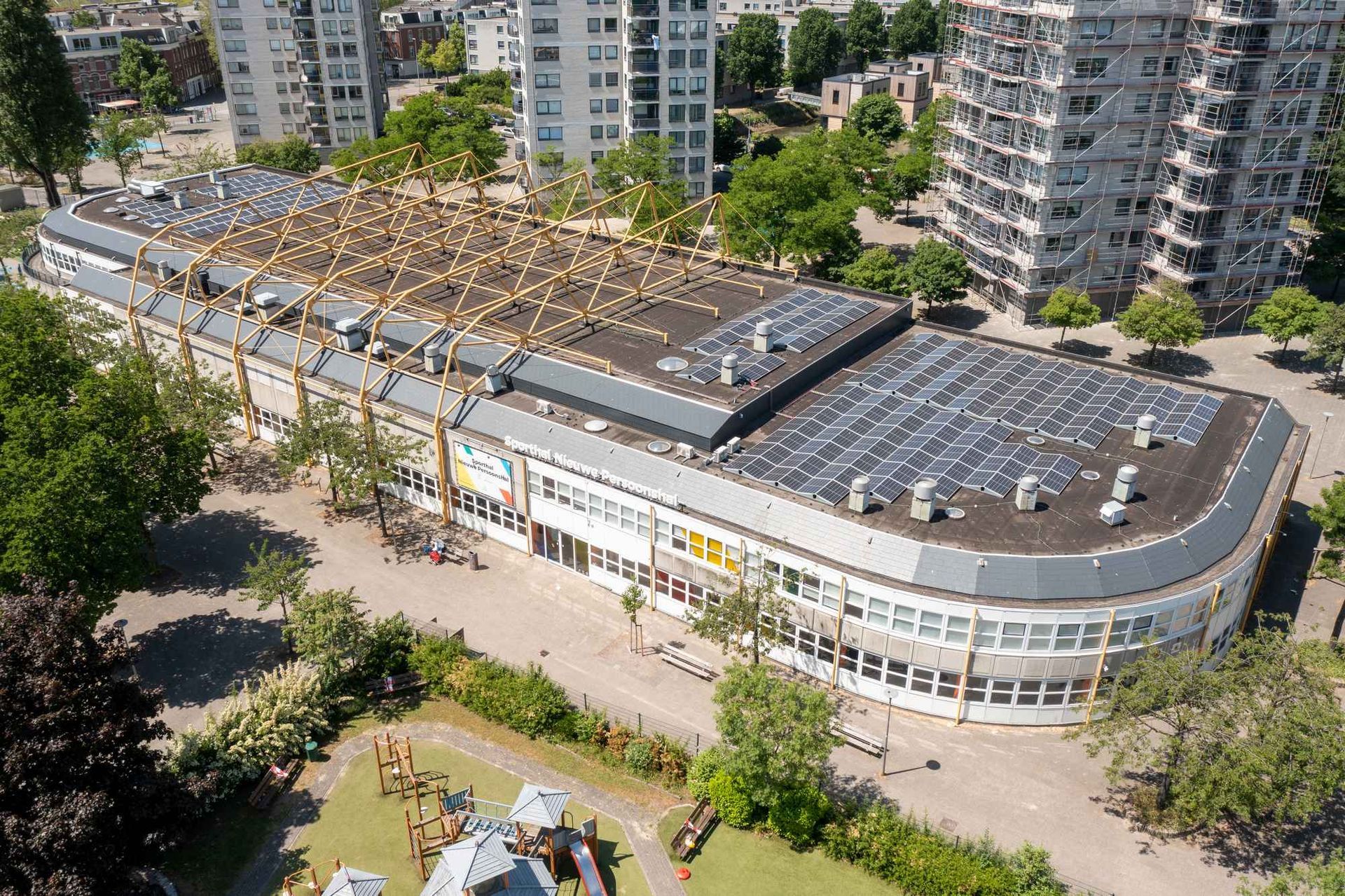 Een luchtfoto van een groot gebouw met zonnepanelen op het dak.