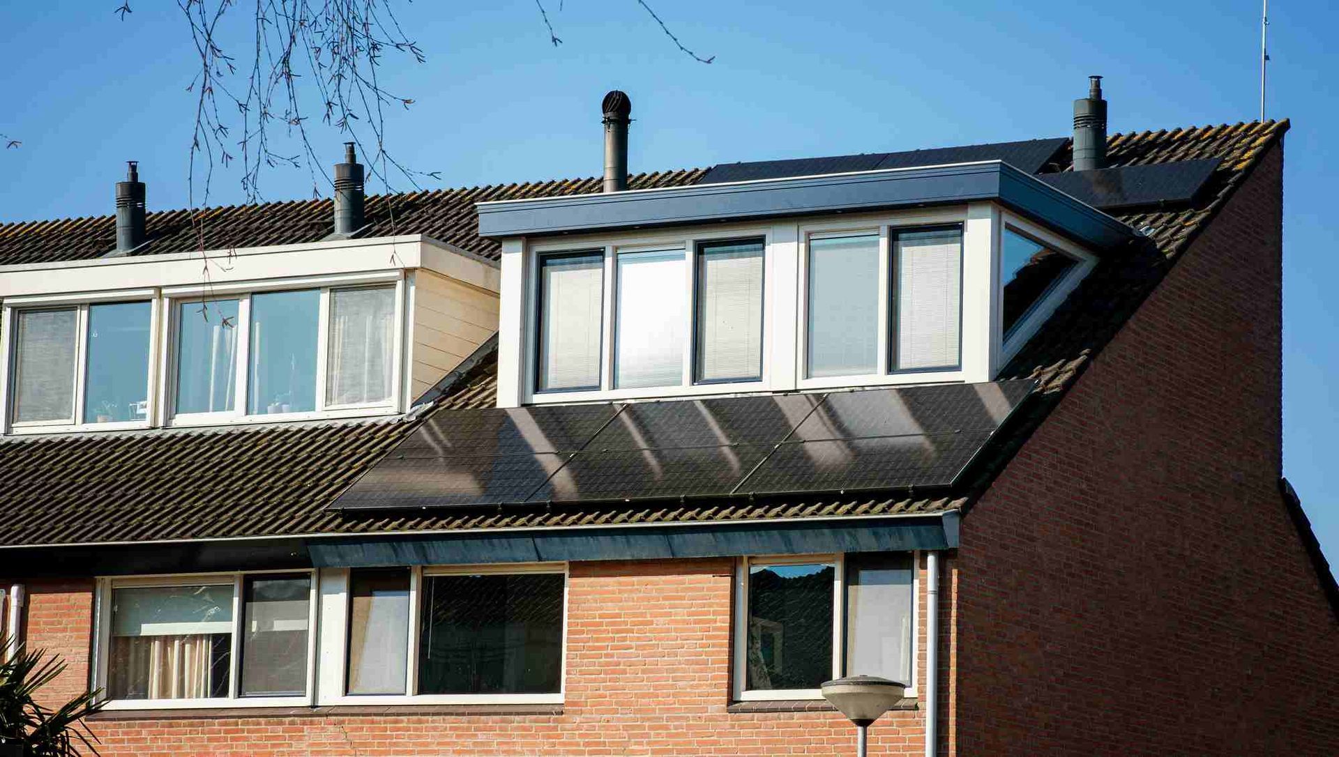 Een bakstenen huis met zonnepanelen op het dak