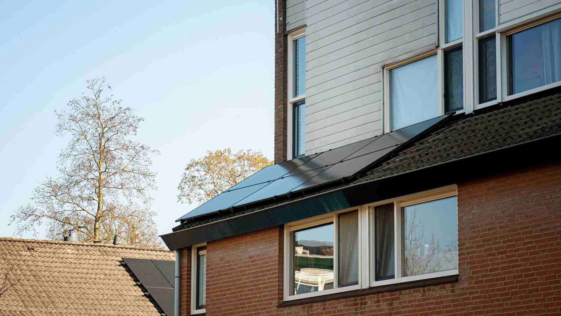 Een bakstenen gebouw met zonnepanelen aan de zijkant.