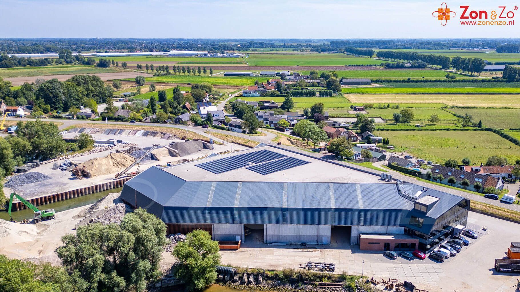 Een luchtfoto van een groot gebouw met zonnepanelen op het dak.
