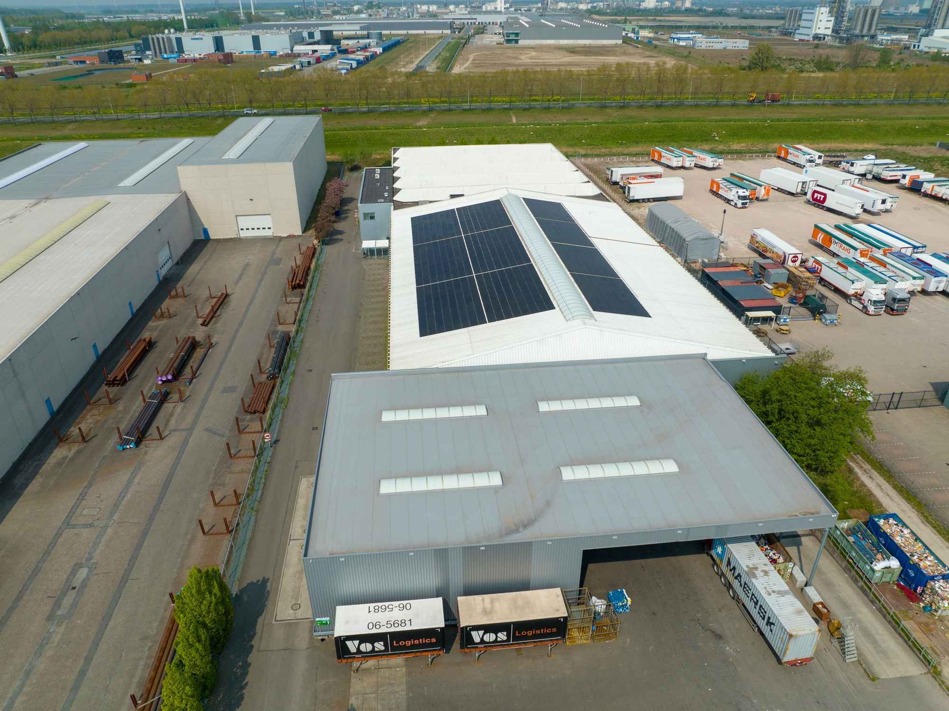 Een luchtfoto van een magazijn met zonnepanelen op het dak