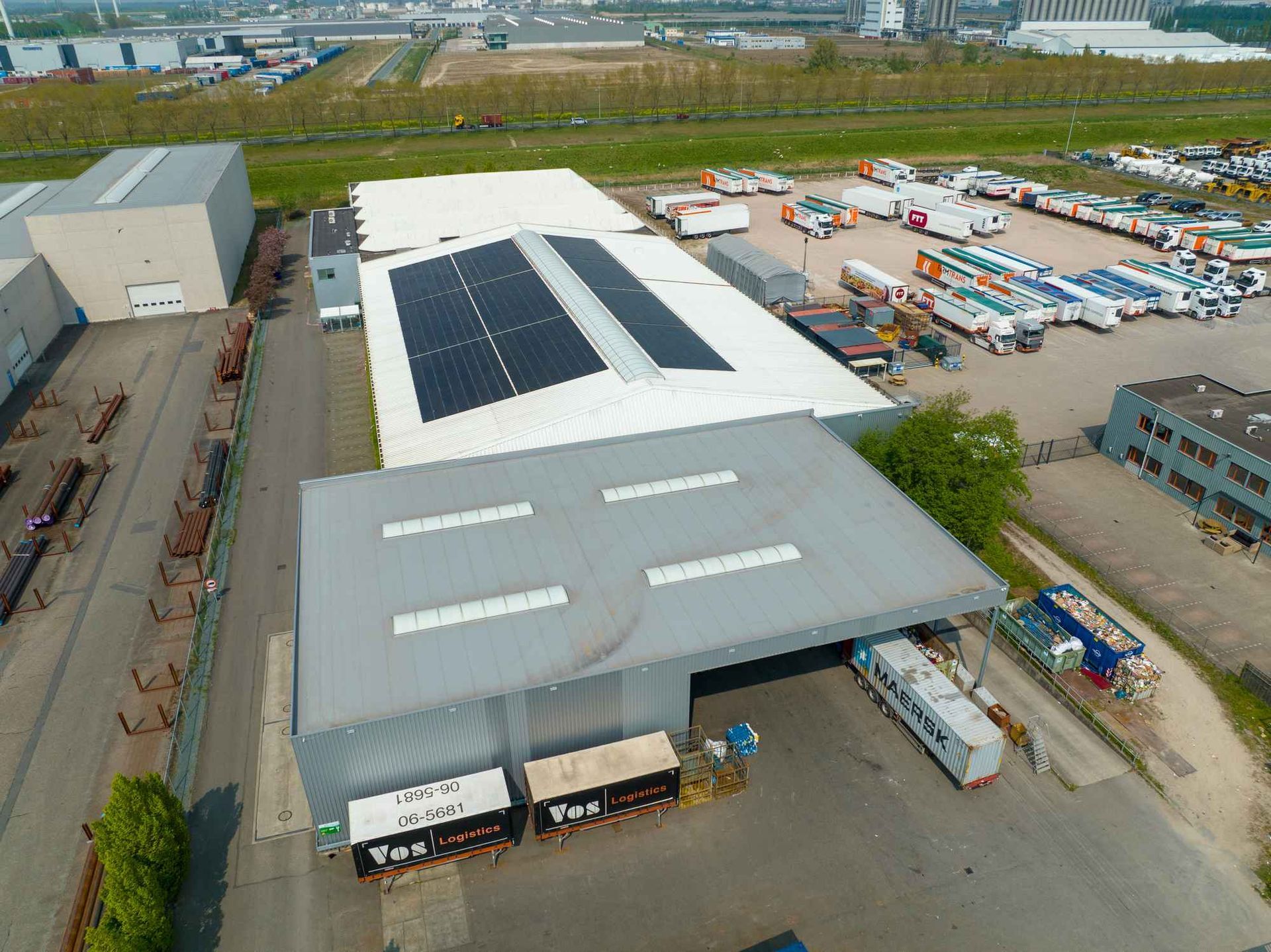 Een luchtfoto van een magazijn met zonnepanelen op het dak.