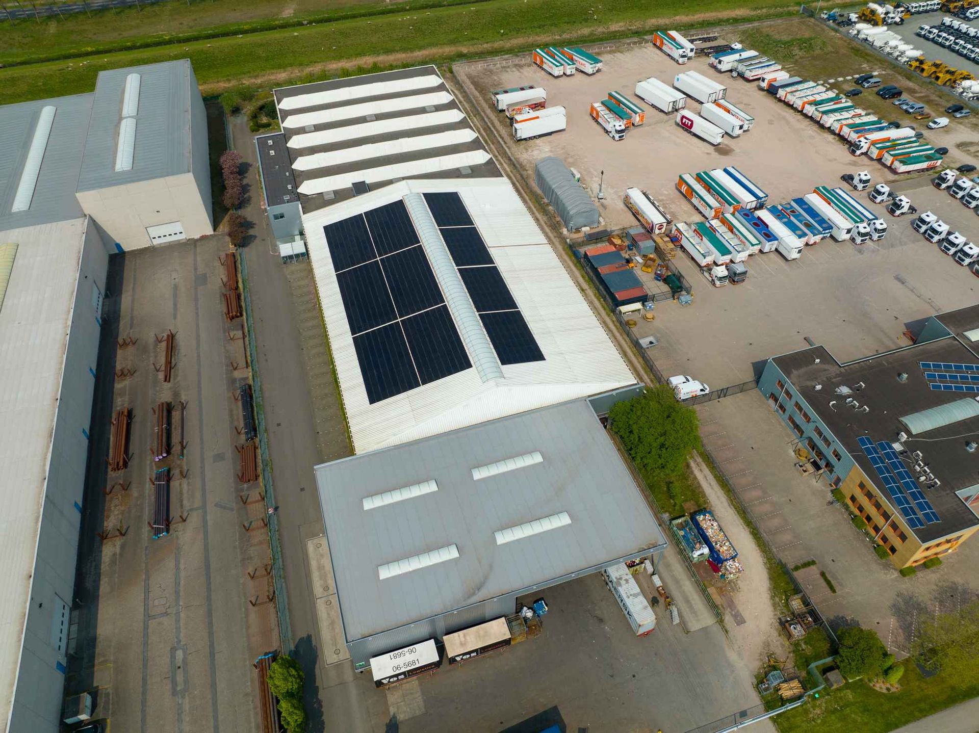 Een luchtfoto van een groot gebouw met zonnepanelen op het dak.