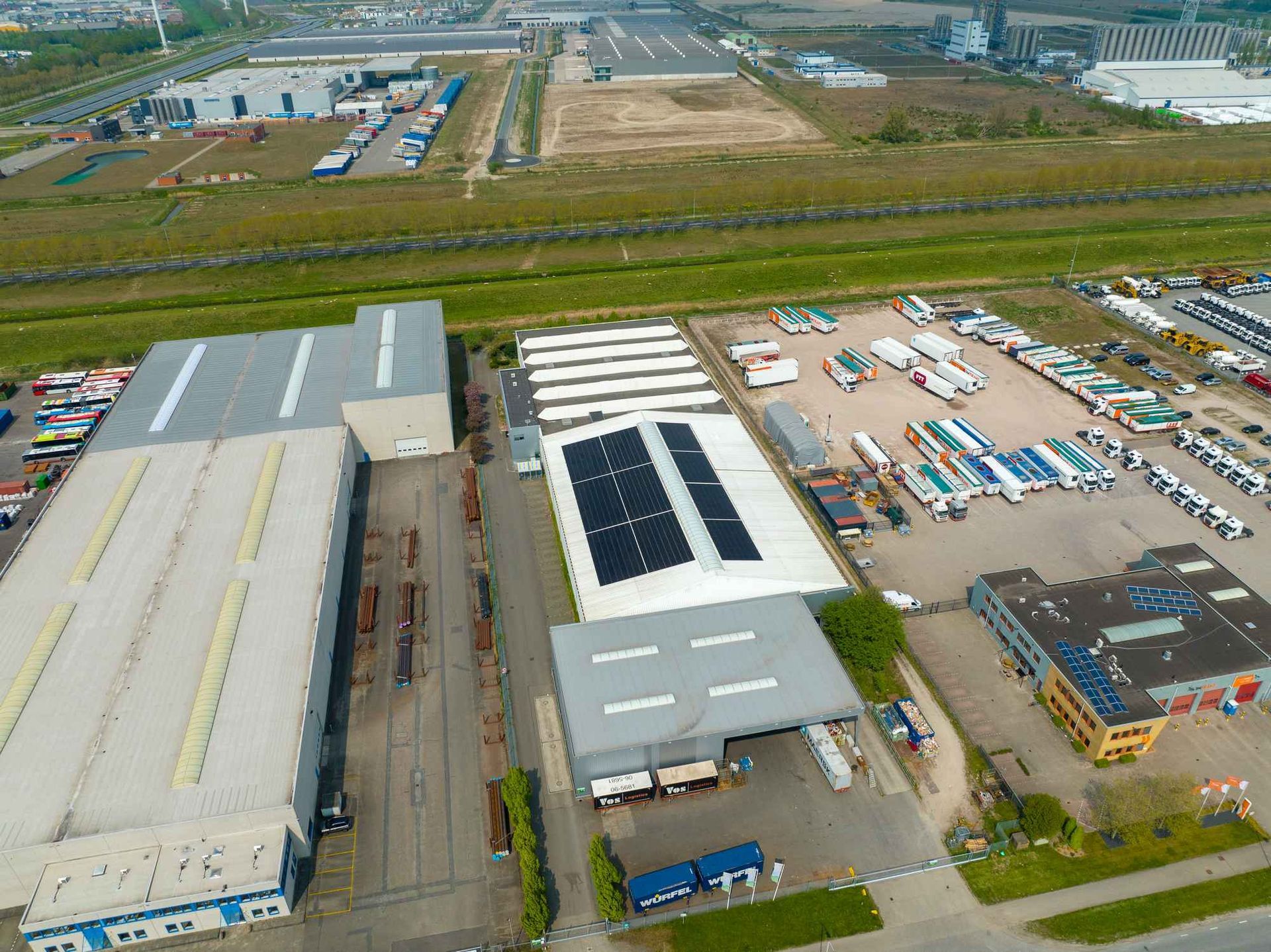 Een luchtfoto van een magazijn met zonnepanelen op het dak.