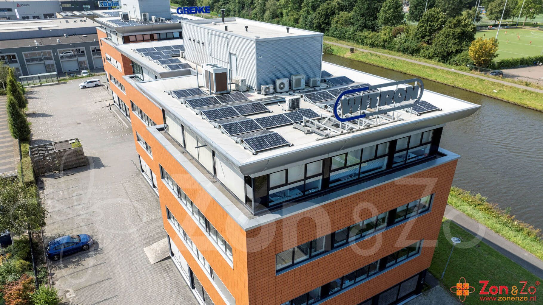 Een luchtfoto van een groot gebouw met zonnepanelen op het dak