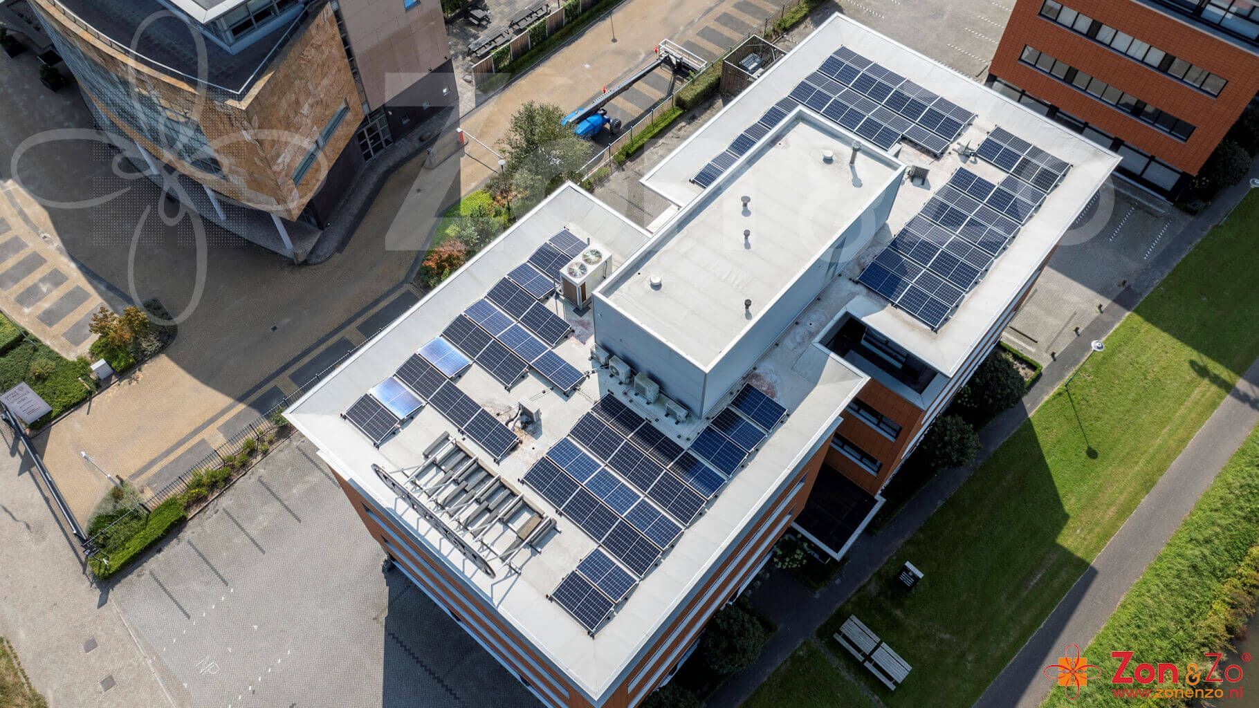 Een luchtfoto van een groot gebouw met zonnepanelen op het dak.