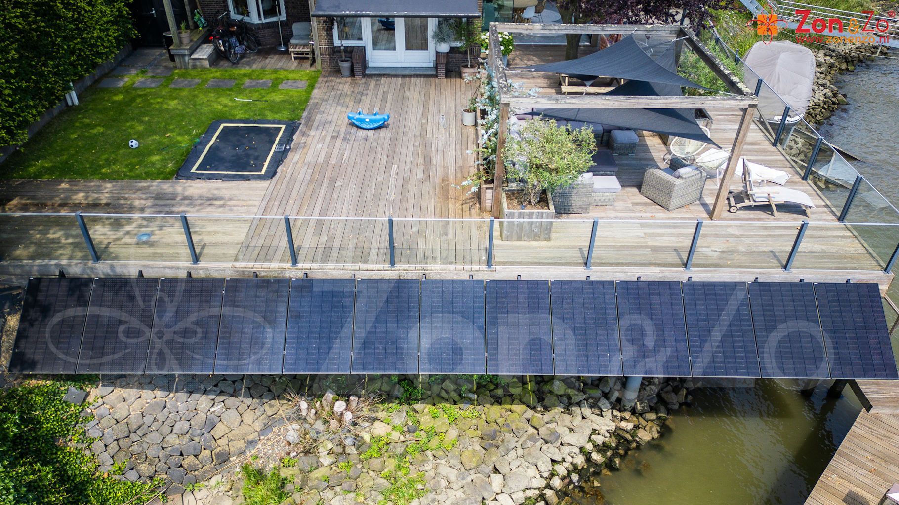 Een luchtfoto van een huis met een brug over een watermassa.