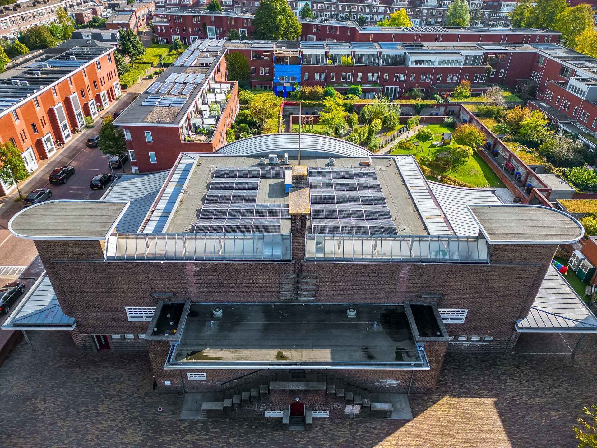 Een luchtfoto van een groot bakstenen gebouw met een koepeldak in een stad.