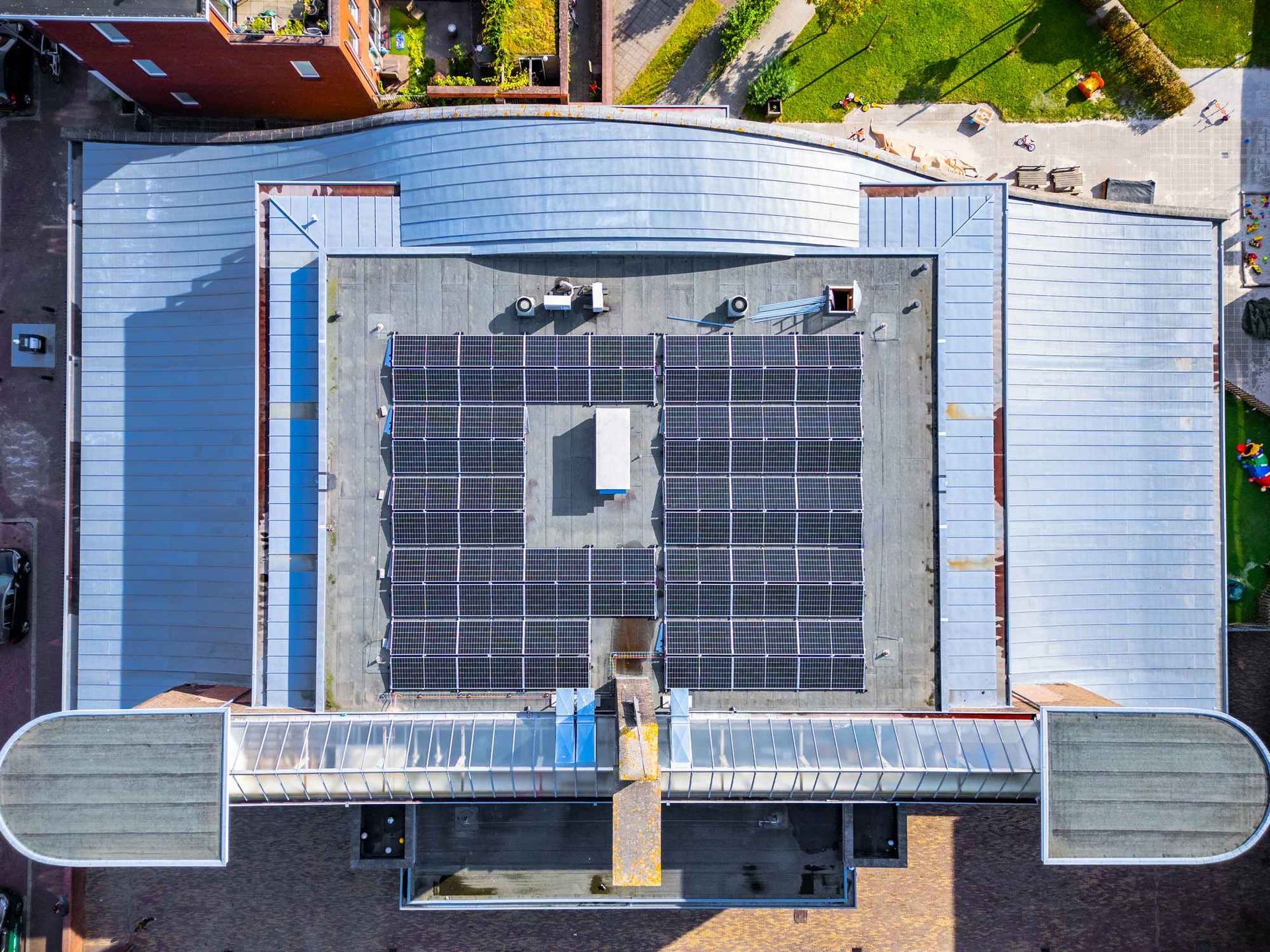 Een luchtfoto van een gebouw met zonnepanelen op het dak.