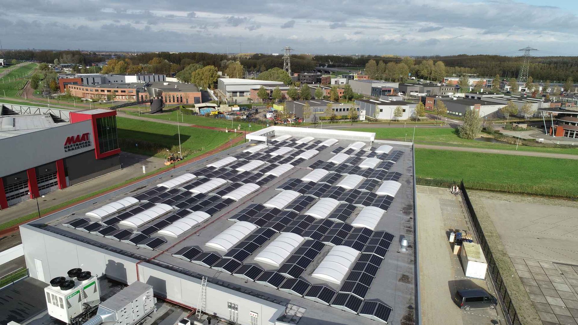 Een luchtfoto van een groot gebouw met zonnepanelen op het dak.