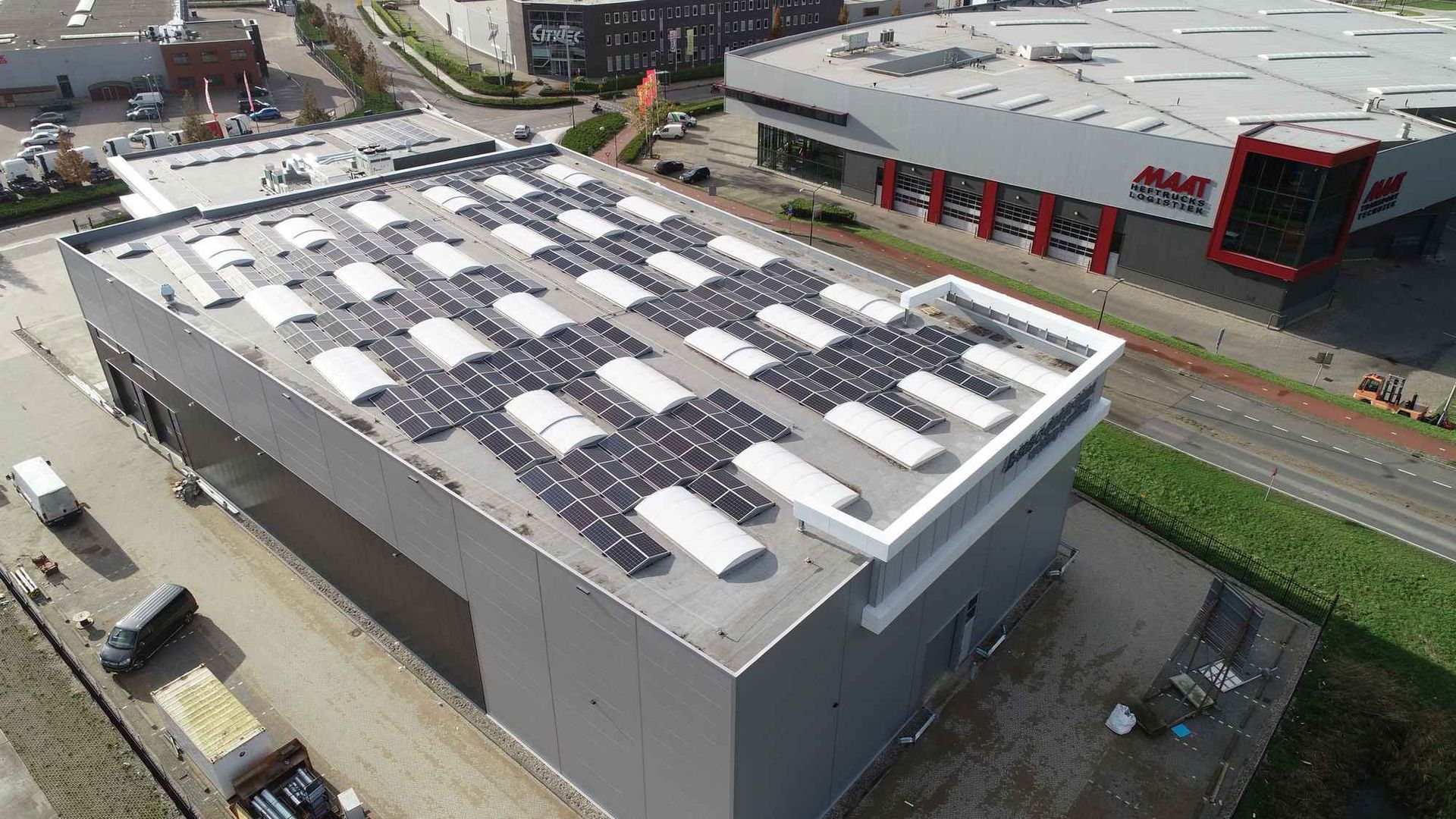 Een luchtfoto van een groot gebouw met zonnepanelen op het dak.