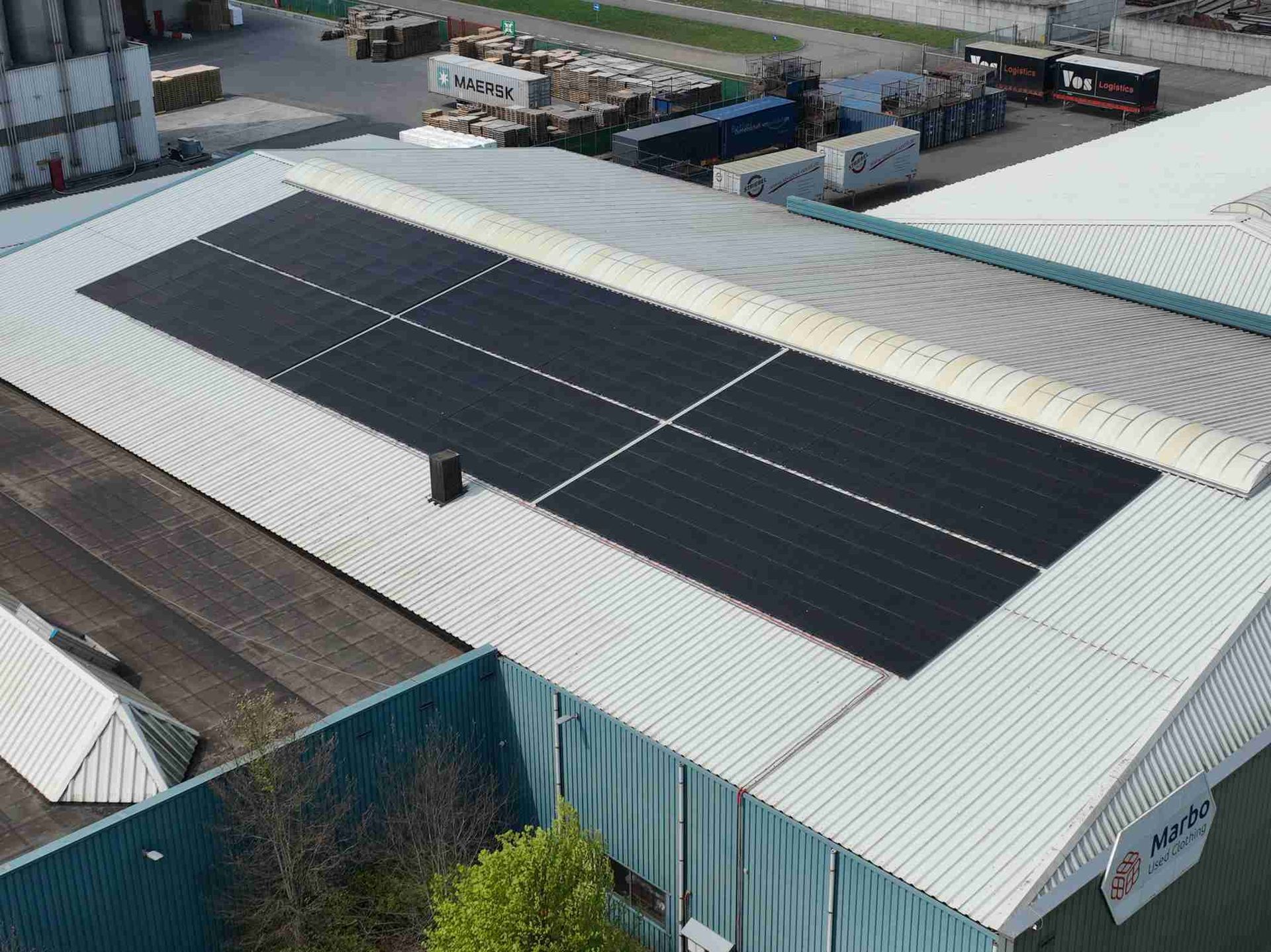 Een luchtfoto van een groot gebouw met zonnepanelen op het dak.