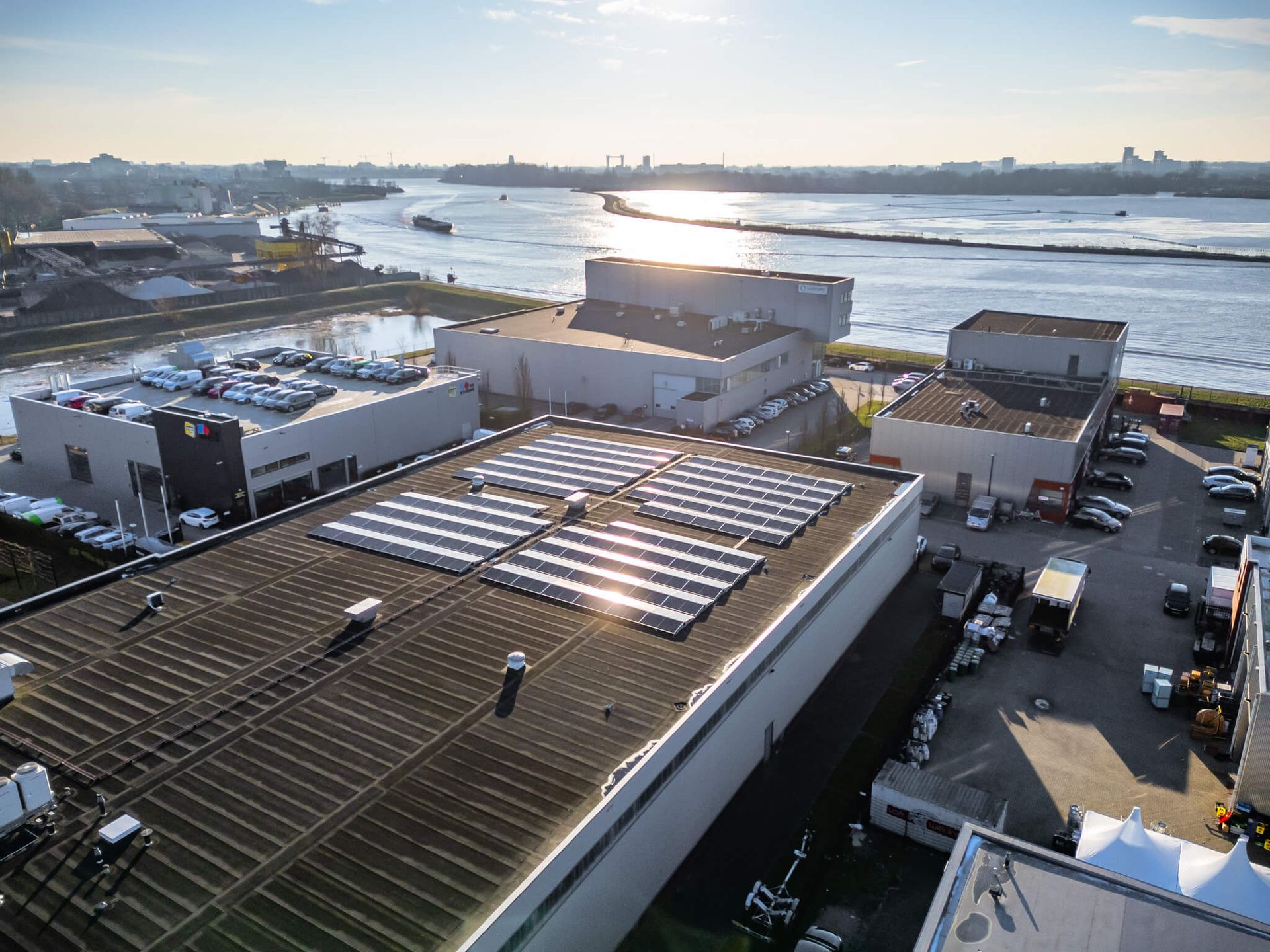 Een luchtfoto van een gebouw met zonnepanelen op het dak.