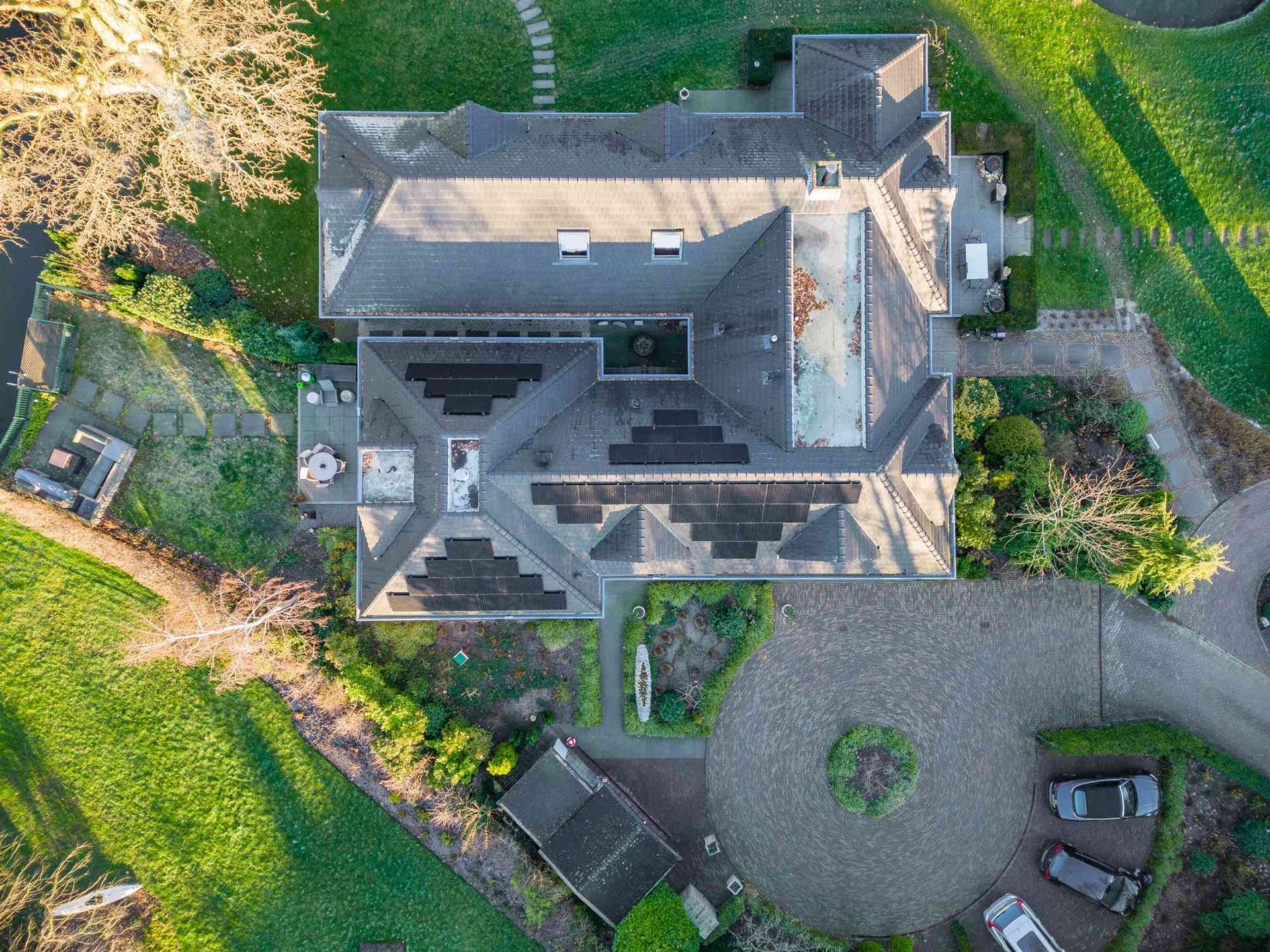 Een luchtfoto van een groot huis met veel zonnepanelen op het dak.